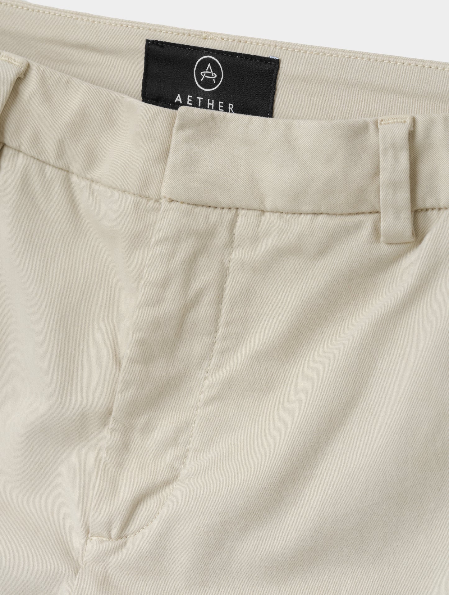 Closeup detailed view of the front closure and waistband on the Rhy Straight Leg Pant in Bone from AETHER Apparel.