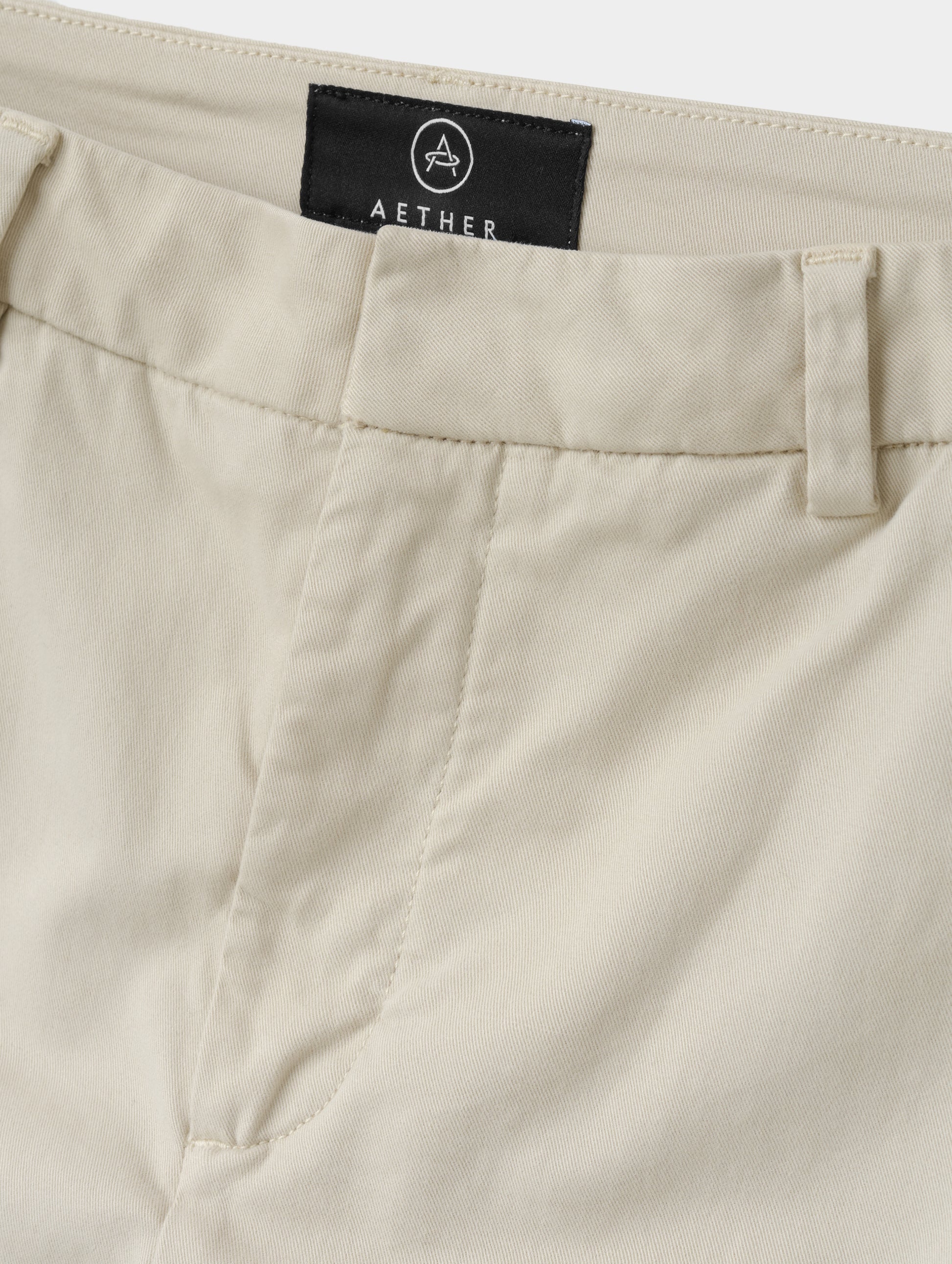 Closeup detailed view of the front closure and waistband on the Rhy Straight Leg Pant in Bone from AETHER Apparel.