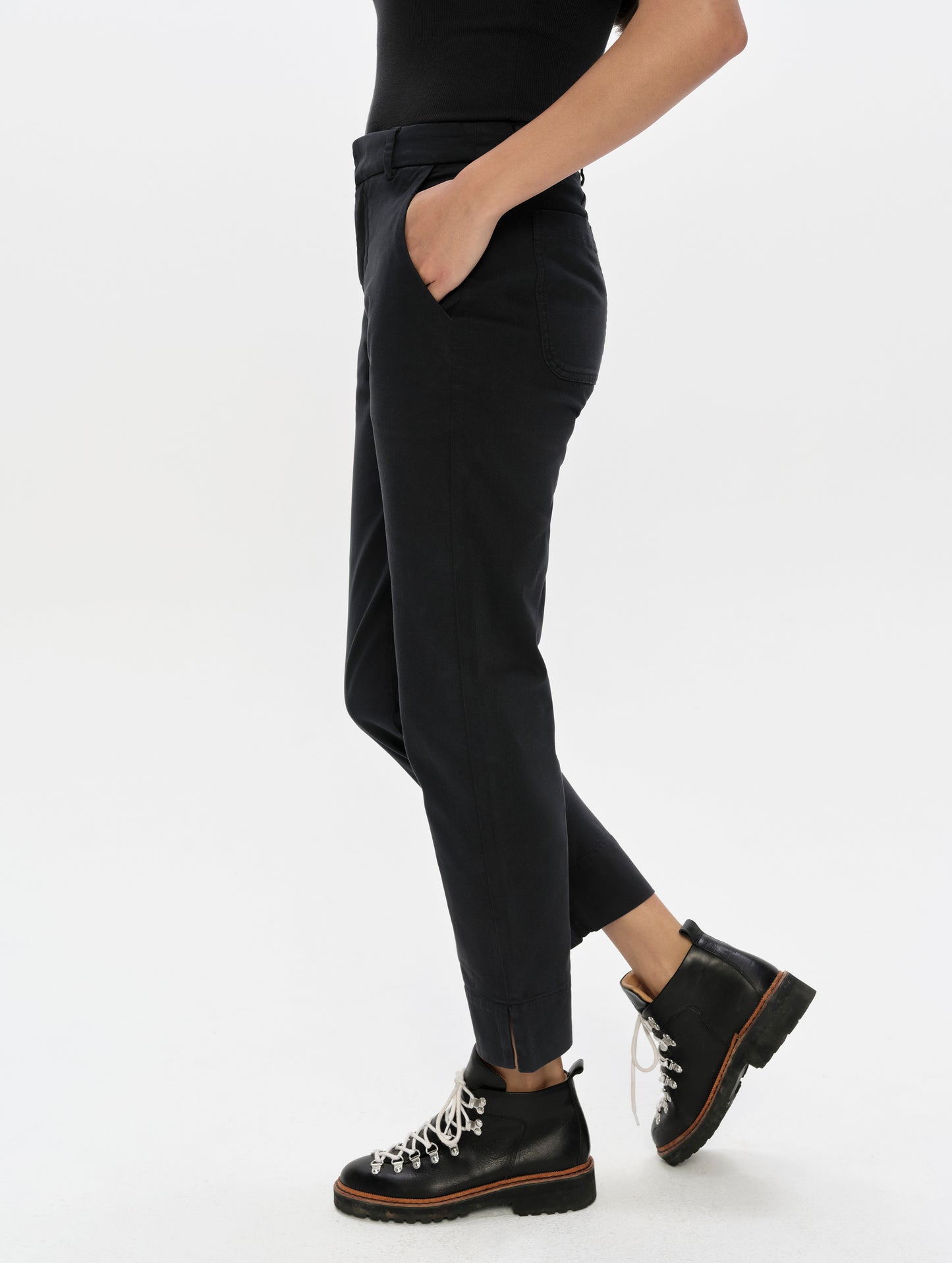 Side profile, lower-body view of woman wearing the Rhy Straight Leg Pant in Onyx Black from AETHER Apparel.