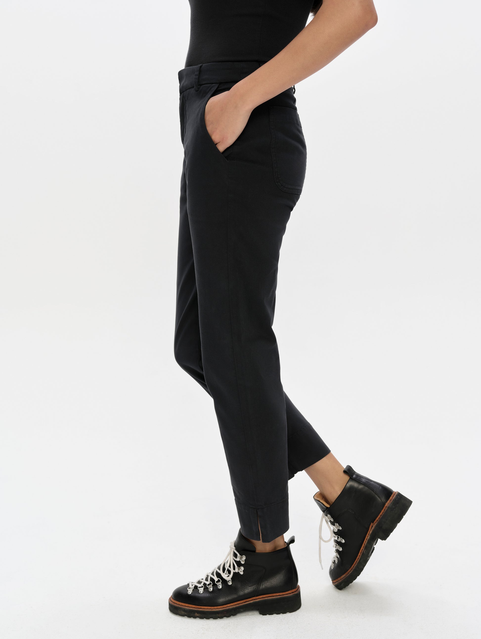 Side profile, lower-body view of woman wearing the Rhy Straight Leg Pant in Onyx Black from AETHER Apparel.