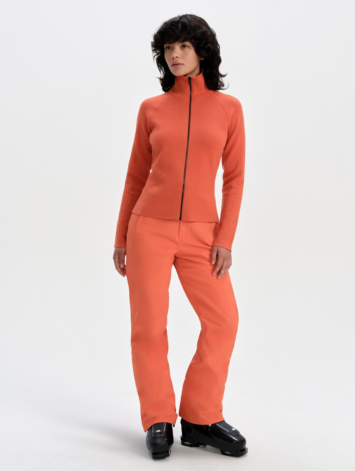 Front full-body view of woman wearing the Riley Full-Zip Sweater 2.0 in Madeira Orange from AETHER Apparel.