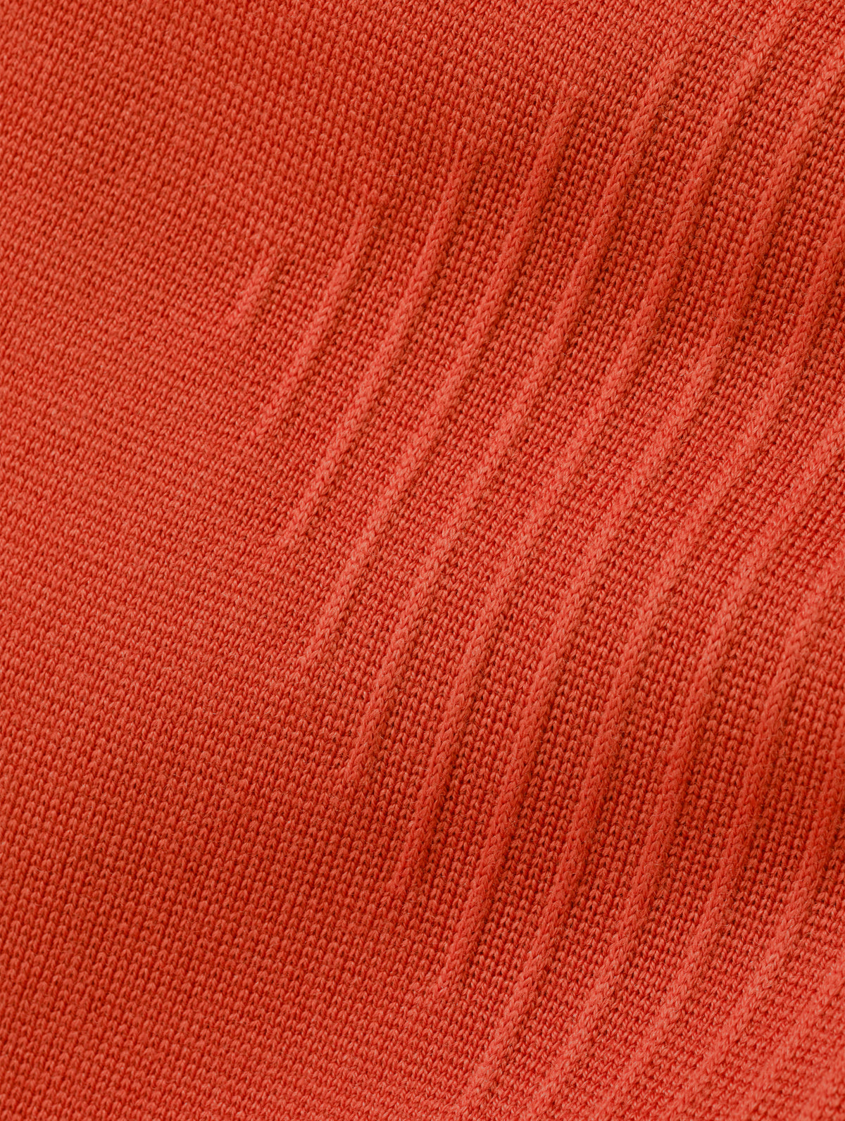 Closeup detailed view of the ottoman stitch details and knitted merino wool construction on the Riley Full-Zip Sweater 2.0 in Madeira Orange from AETHER Apparel.