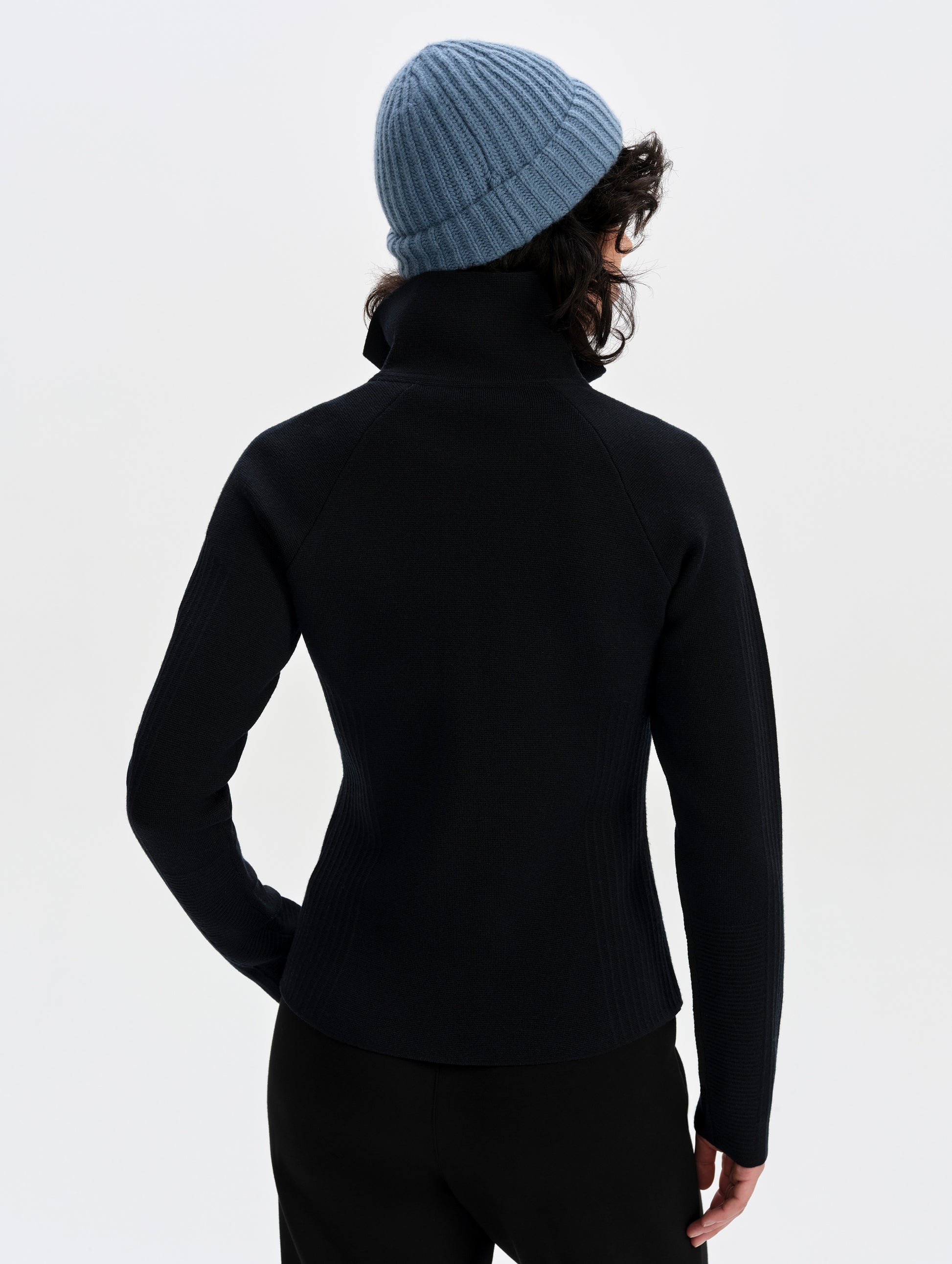 Rear upper-body view of woman wearing the Riley Full-Zip Sweater 2.0 in Onyx Black from AETHER Apparel.
