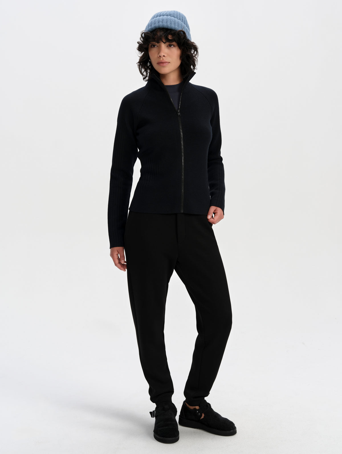 Front full-body view of woman wearing the Riley Full-Zip Sweater 2.0 in Onyx Black from AETHER Apparel.