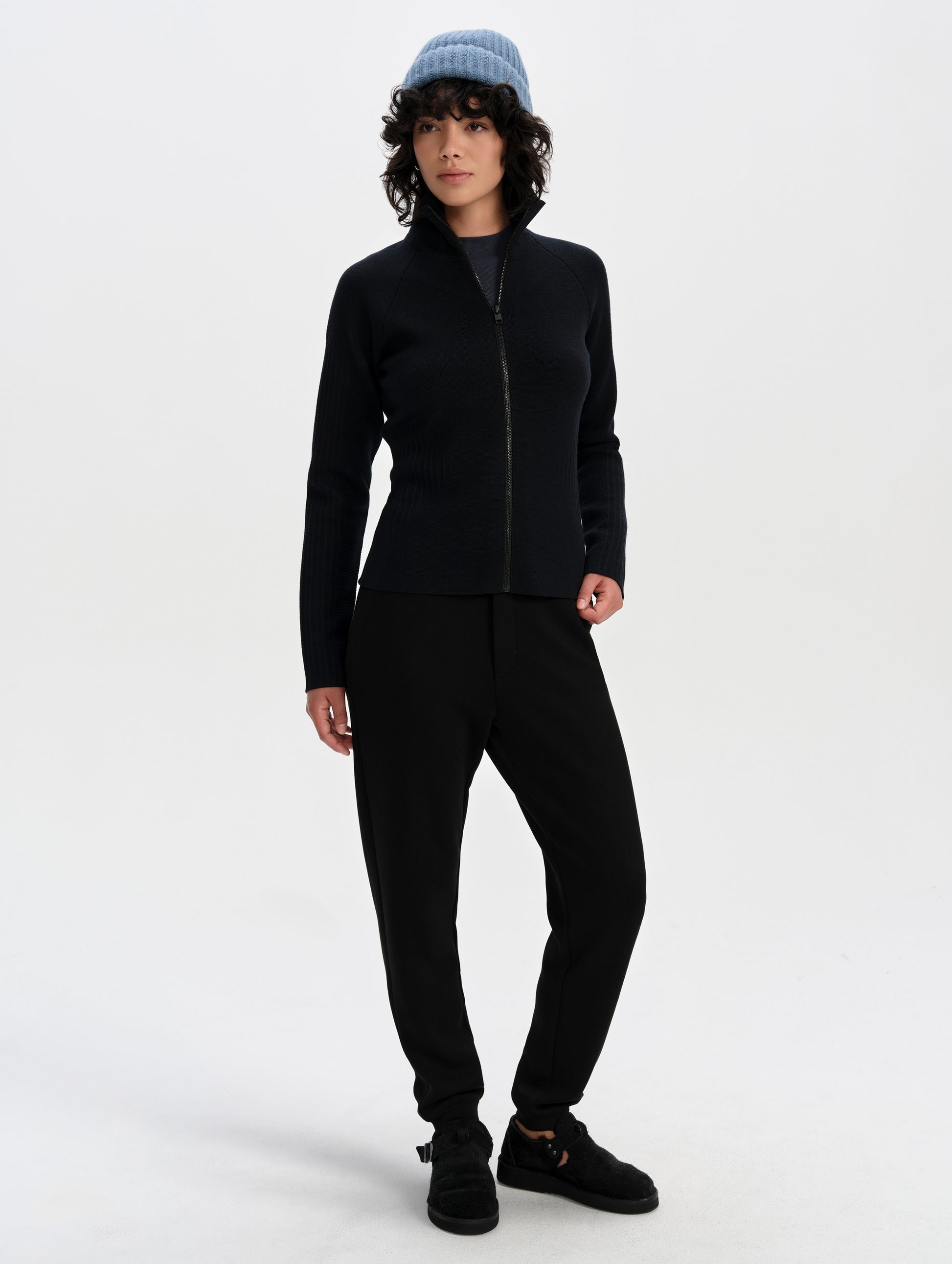 Front full-body view of woman wearing the Riley Full-Zip Sweater 2.0 in Onyx Black from AETHER Apparel.