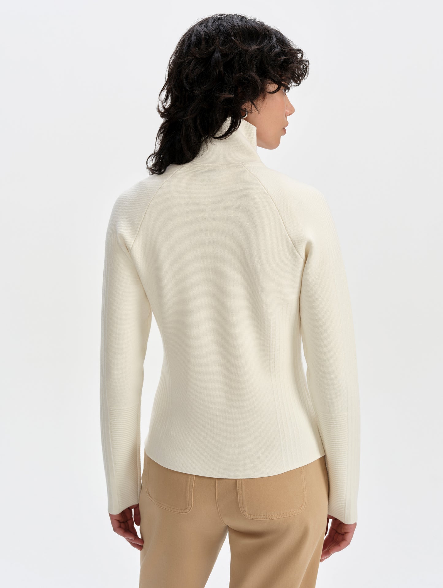 Rear upper-body view of woman wearing the Riley Full-Zip Sweater 2.0 in Winter White from AETHER Apparel.