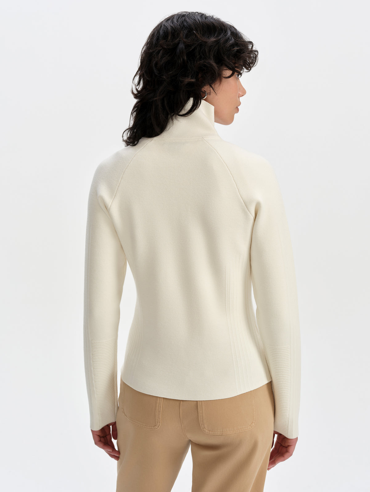 Rear upper-body view of woman wearing the Riley Full-Zip Sweater 2.0 in Winter White from AETHER Apparel.