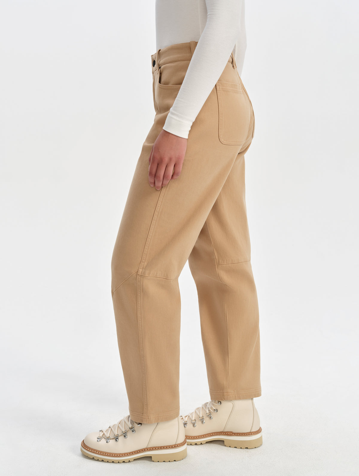 Side profile lower-body view of woman wearing the Rowan Cotton Pant in Latte Brown from AETHER Apparel.