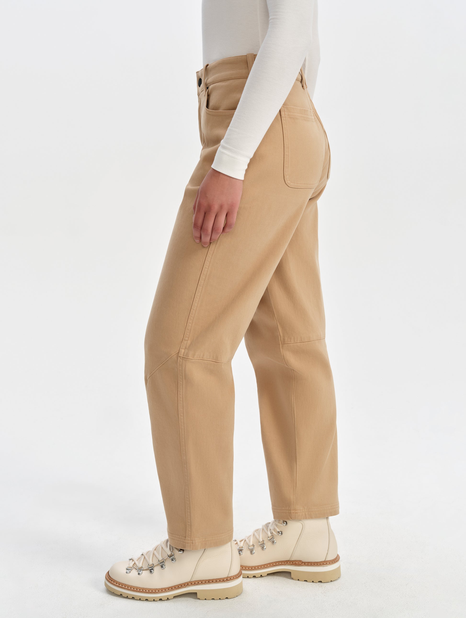 Side profile lower-body view of woman wearing the Rowan Cotton Pant in Latte Brown from AETHER Apparel.