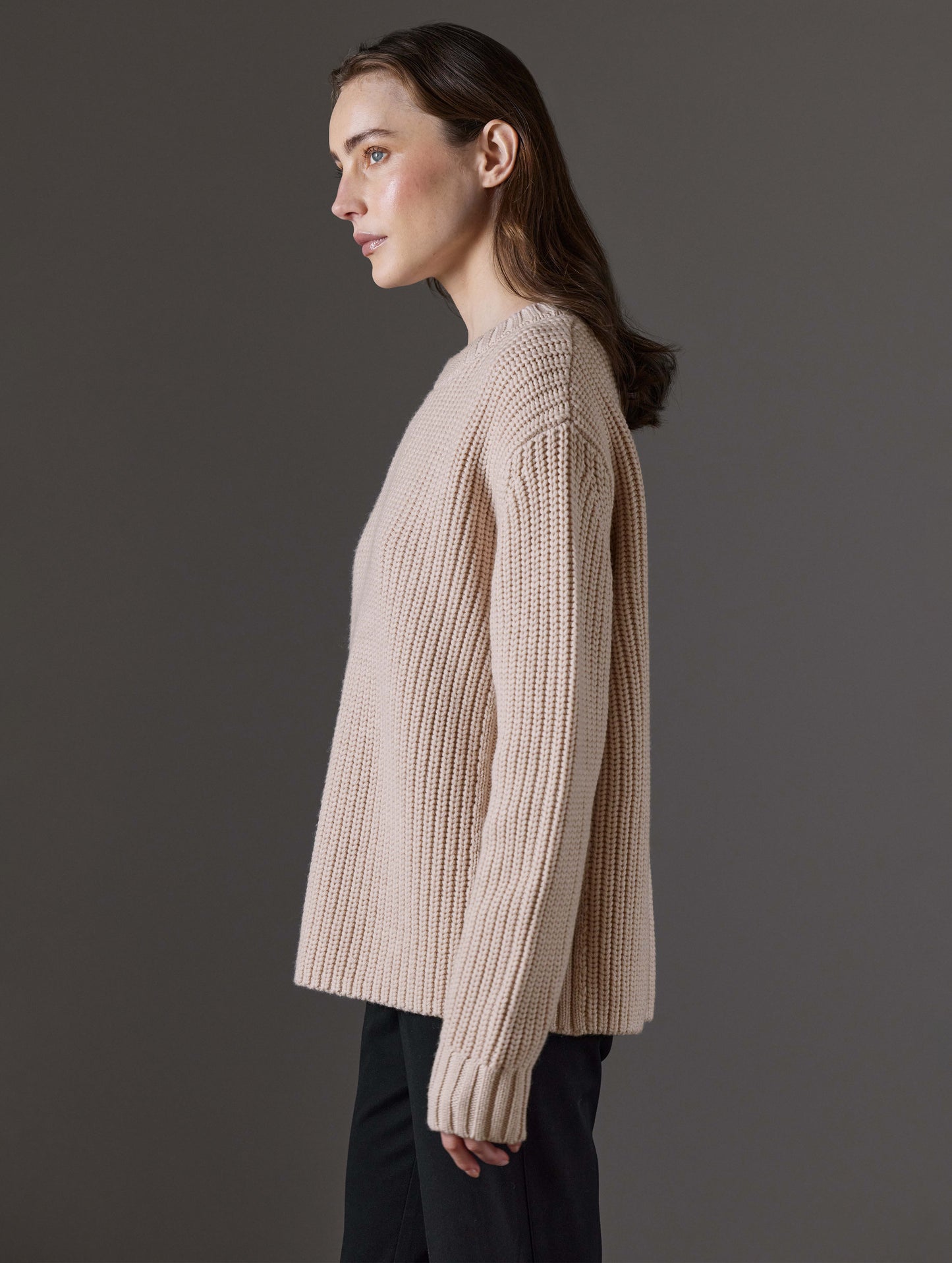 Side profile view of woman wearing Sherwood Crewneck Sweater in Blush beige from AETHER Apparel.