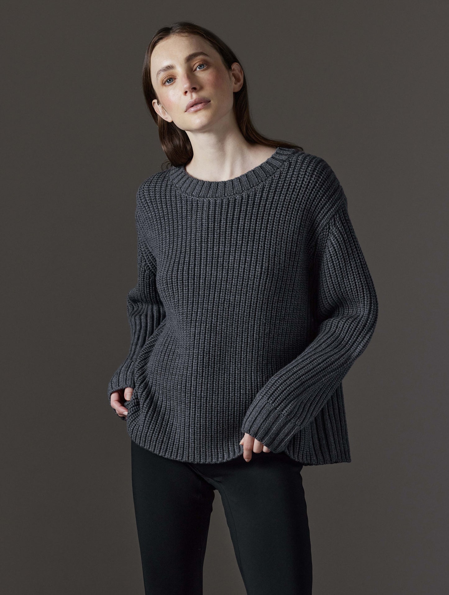 Front angled view of woman wearing Sherwood Crewneck Sweater in Dark Grey Heather from AETHER Apparel.