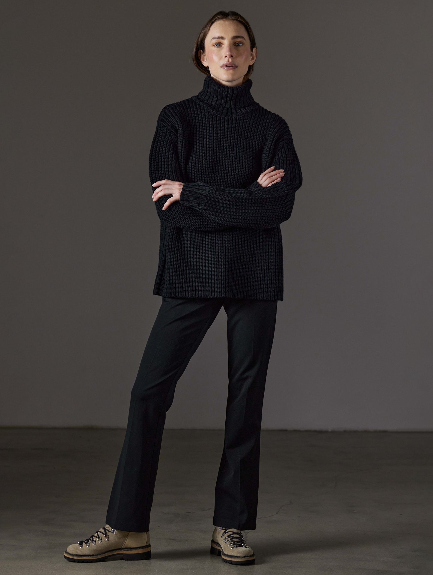 Front full-body view of woman wearing Sherwood Turtleneck Sweater in Onyx Black from AETHER Apparel.