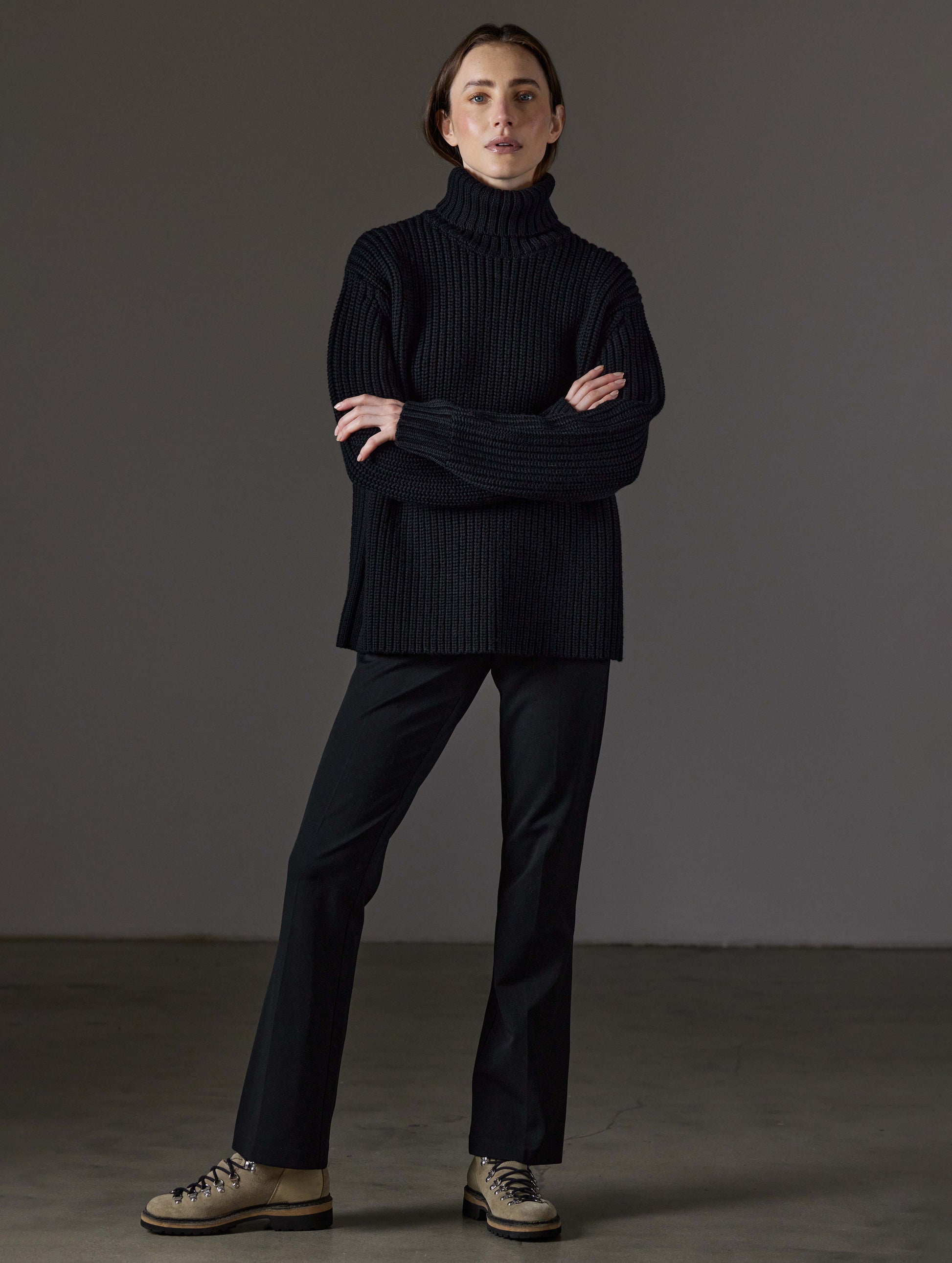 Front full-body view of woman wearing Sherwood Turtleneck Sweater in Onyx Black from AETHER Apparel.