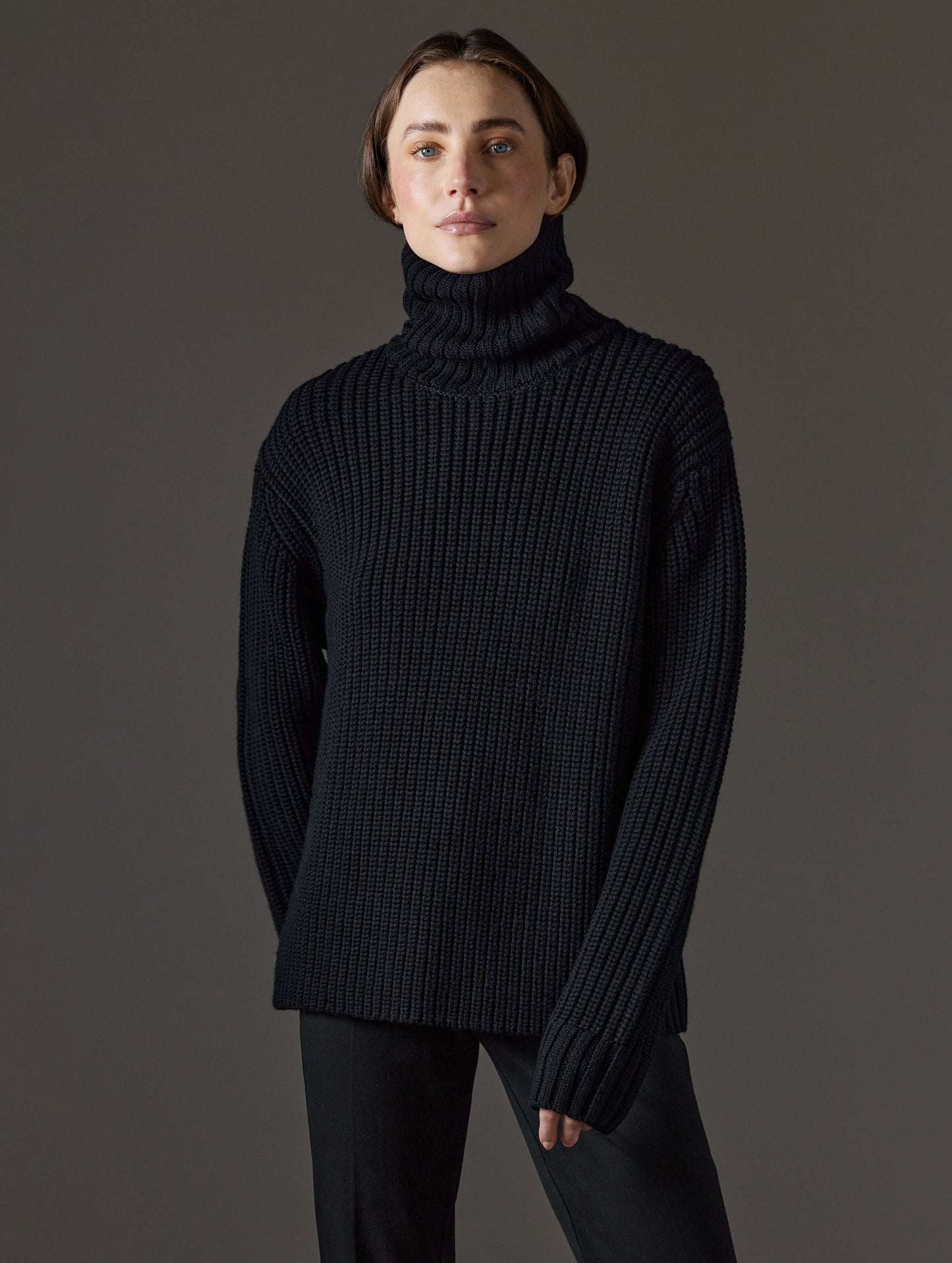 Front view of woman wearing Sherwood Turtleneck Sweater in Onyx Black from AETHER Apparel.