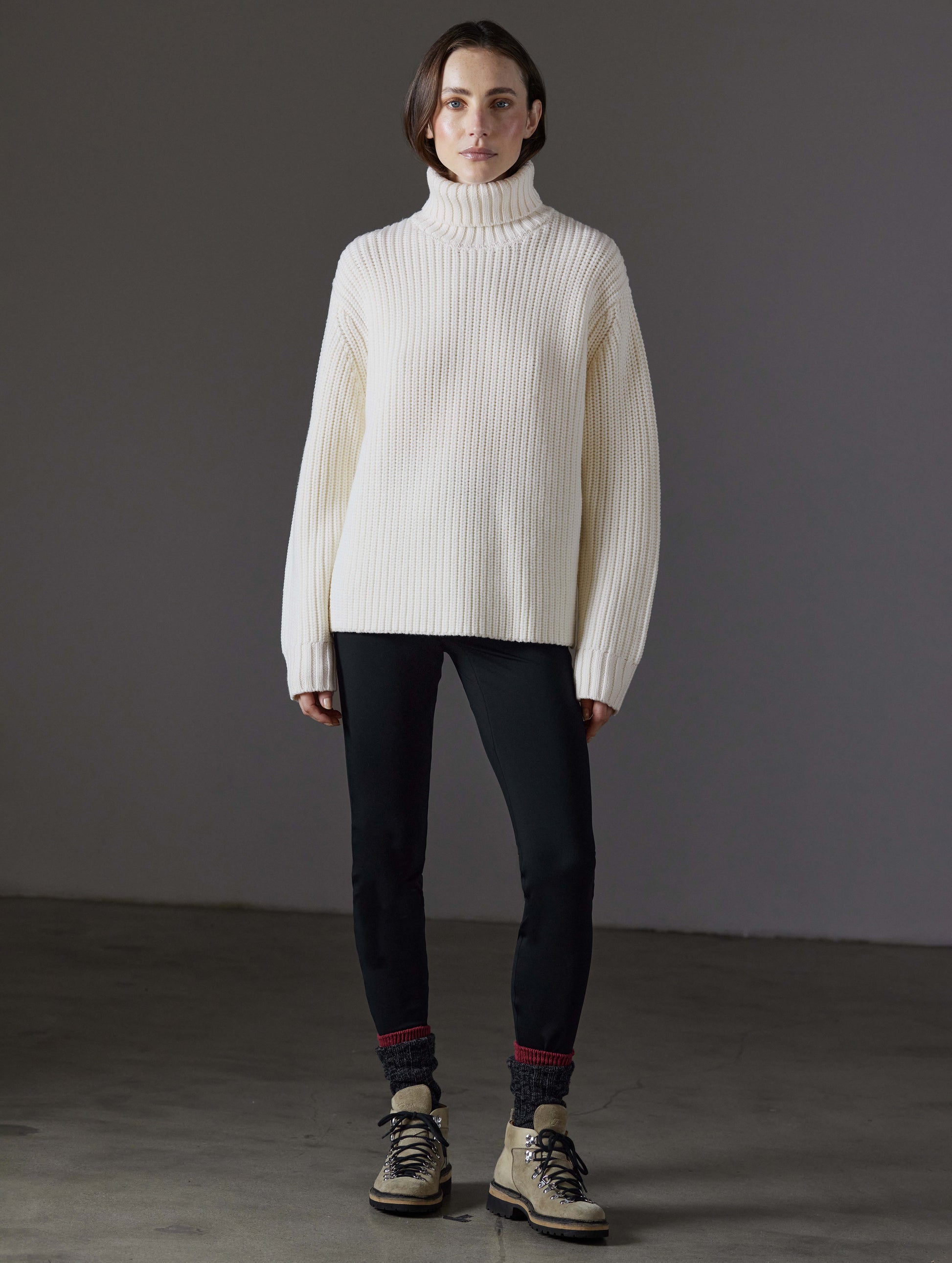 Front full-body view of woman wearing Sherwood Turtleneck Sweater in Winter White from AETHER Apparel.