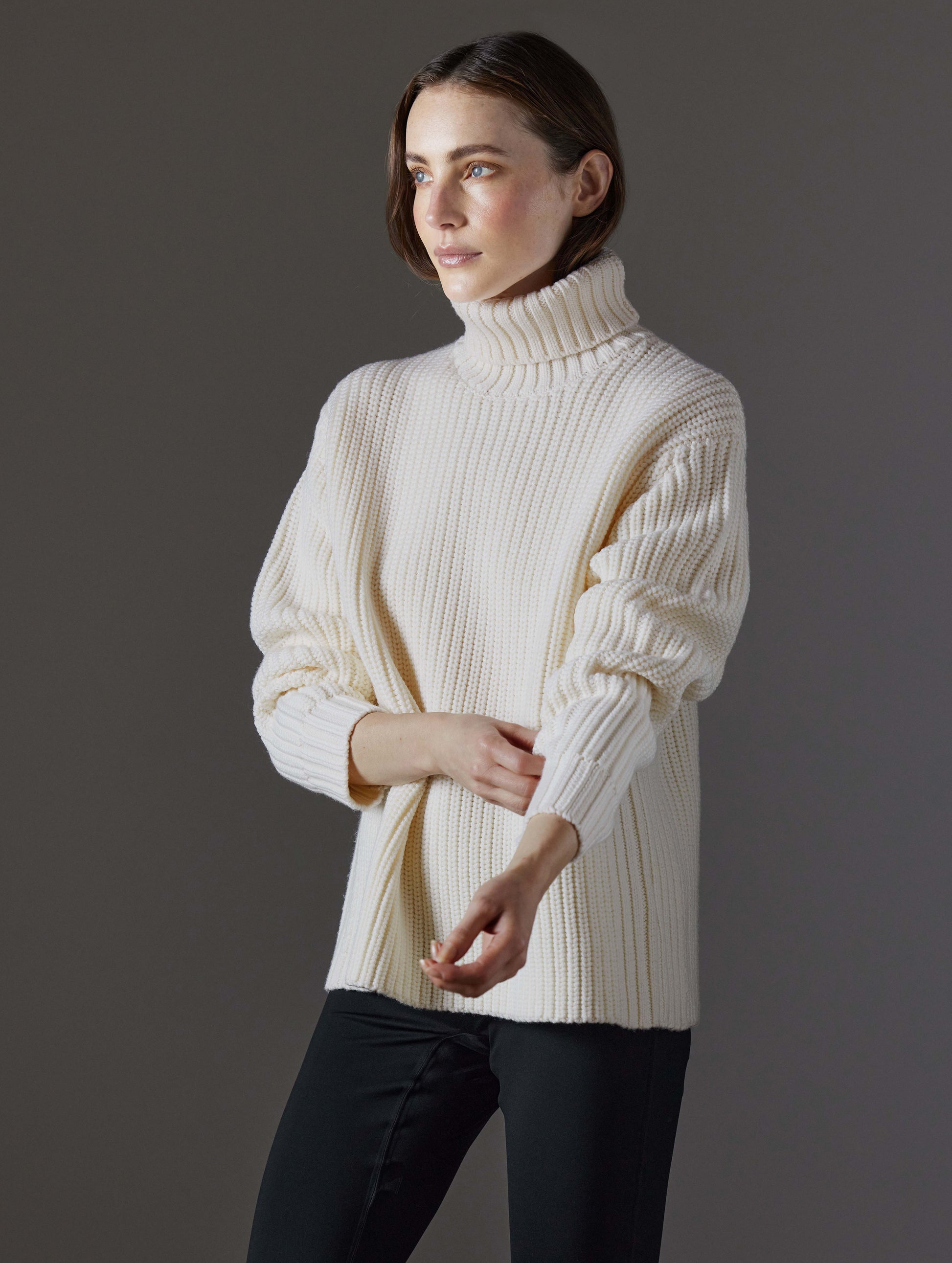 Front angled view of woman wearing Sherwood Turtleneck Sweater in Winter White from AETHER Apparel.