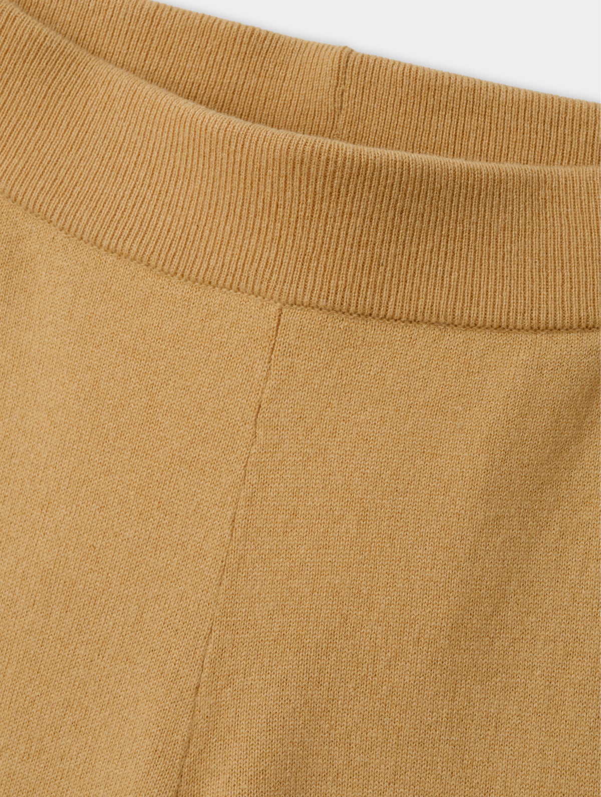Closeup detailed view of the main body fabric and rib-knit waistband on the Solace Cashmere Pant in Latte Brown from AETHER Apparel.