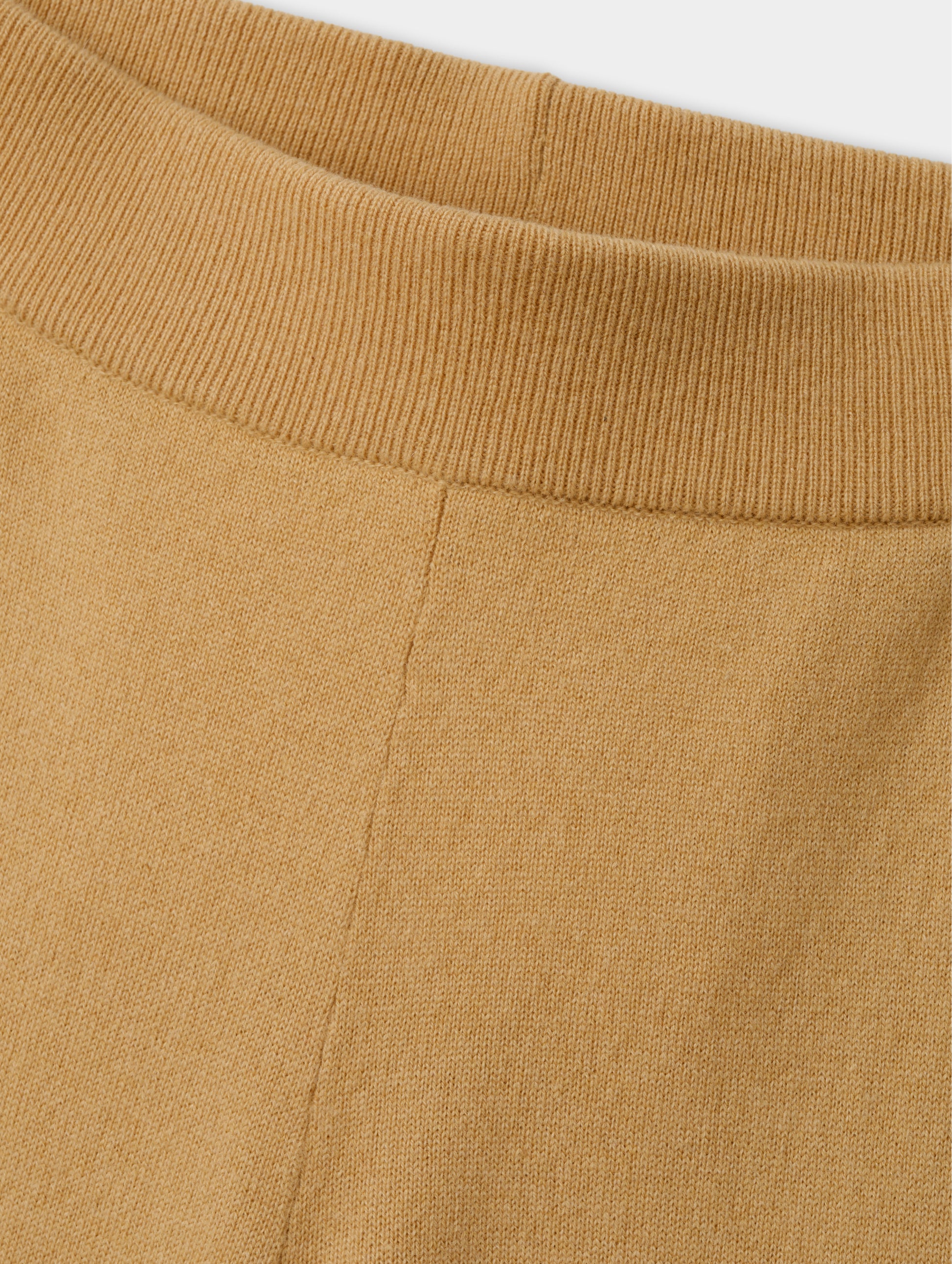 Closeup detailed view of the main body fabric and rib-knit waistband on the Solace Cashmere Pant in Latte Brown from AETHER Apparel.
