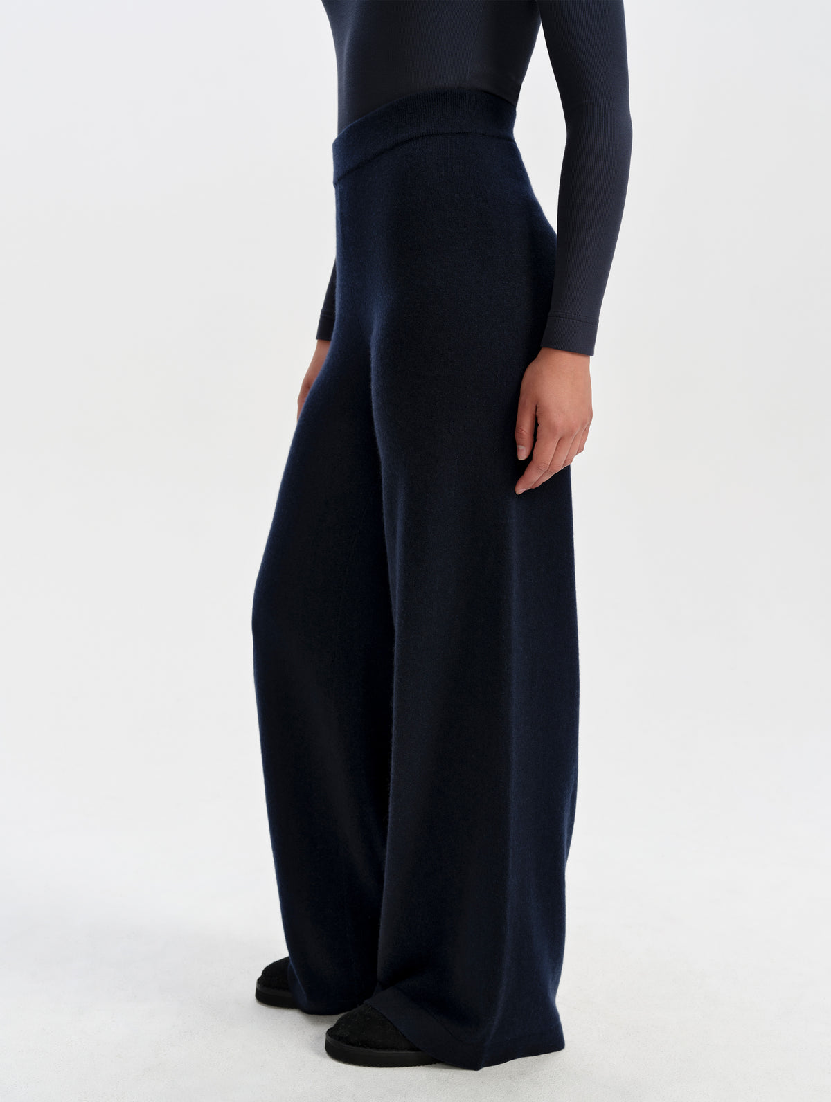 Side profile lower-body view of woman wearing the Solace Cashmere Pant in Total Eclipse from AETHER Apparel.