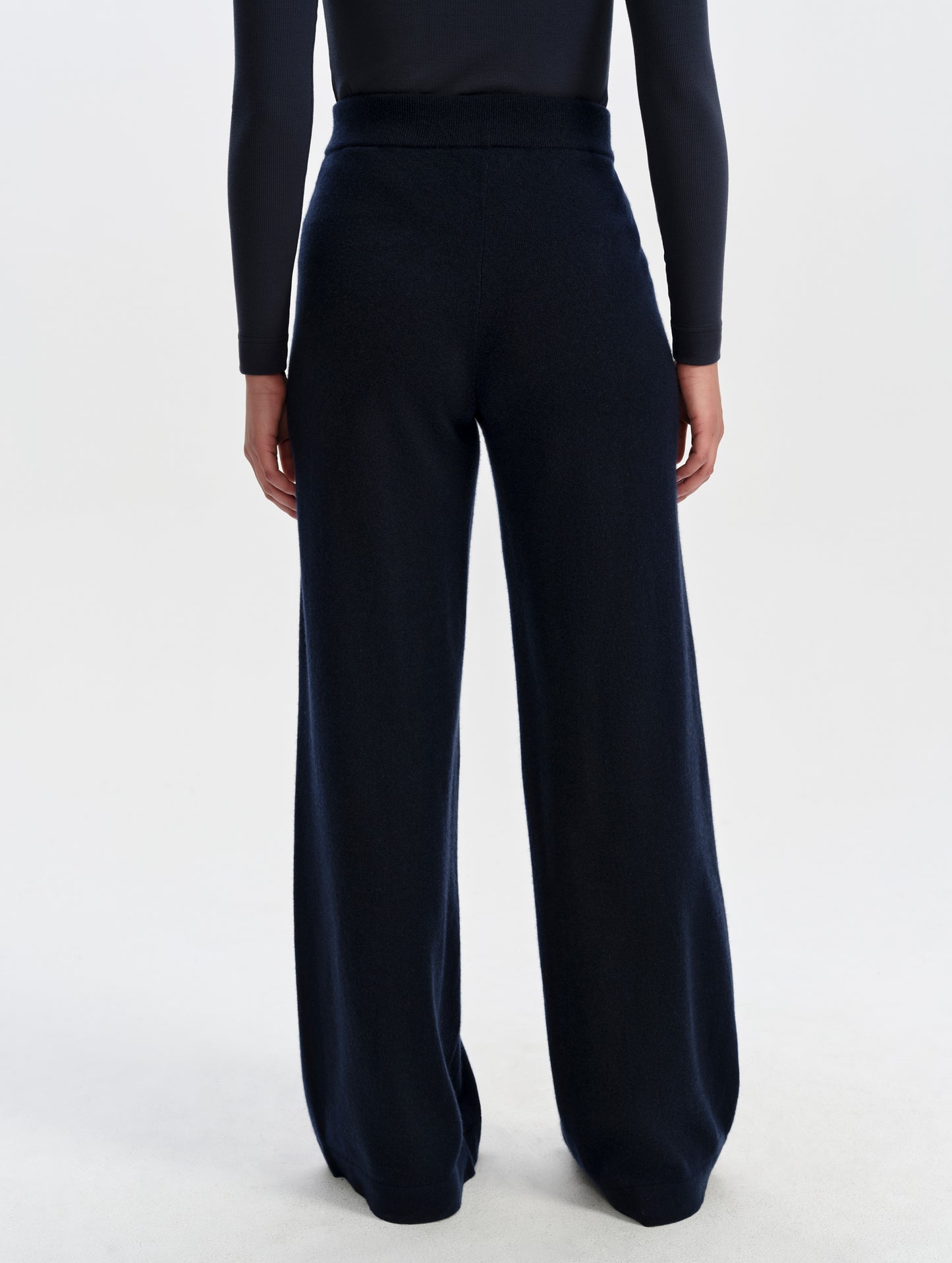 Rear lower-body view of woman wearing the Solace Cashmere Pant in Total Eclipse from AETHER Apparel.