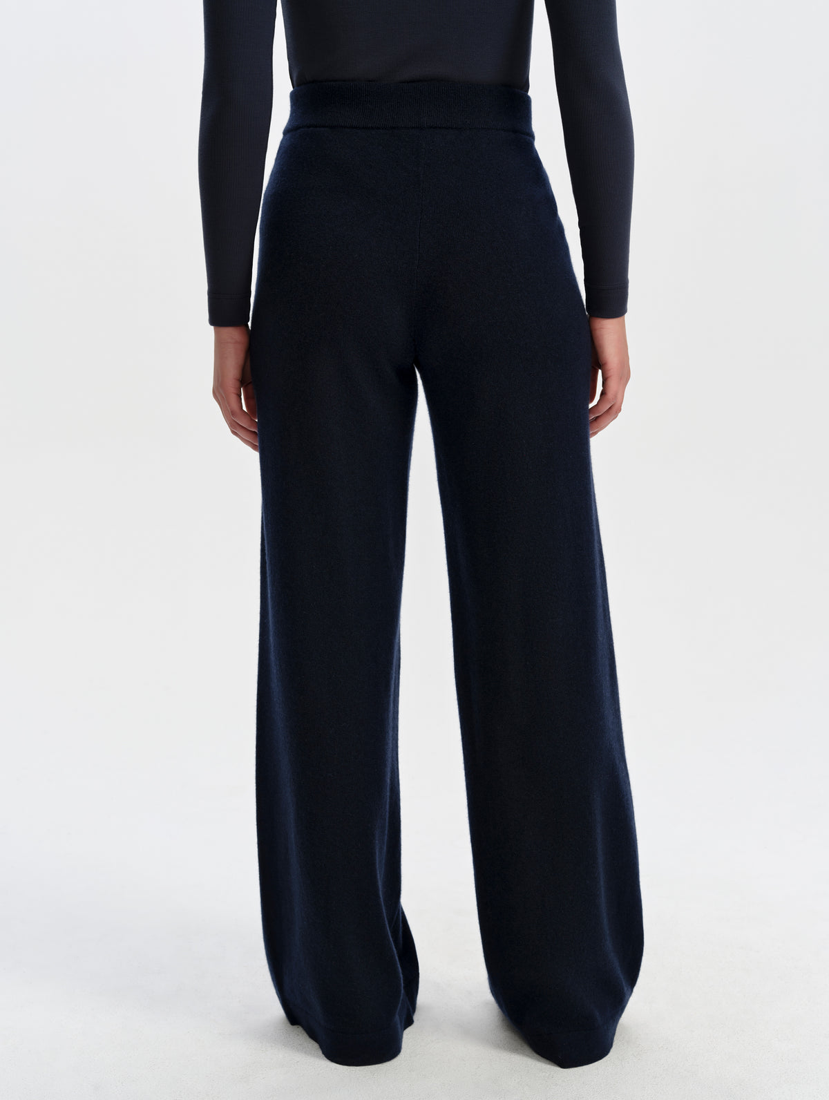 Rear lower-body view of woman wearing the Solace Cashmere Pant in Total Eclipse from AETHER Apparel.