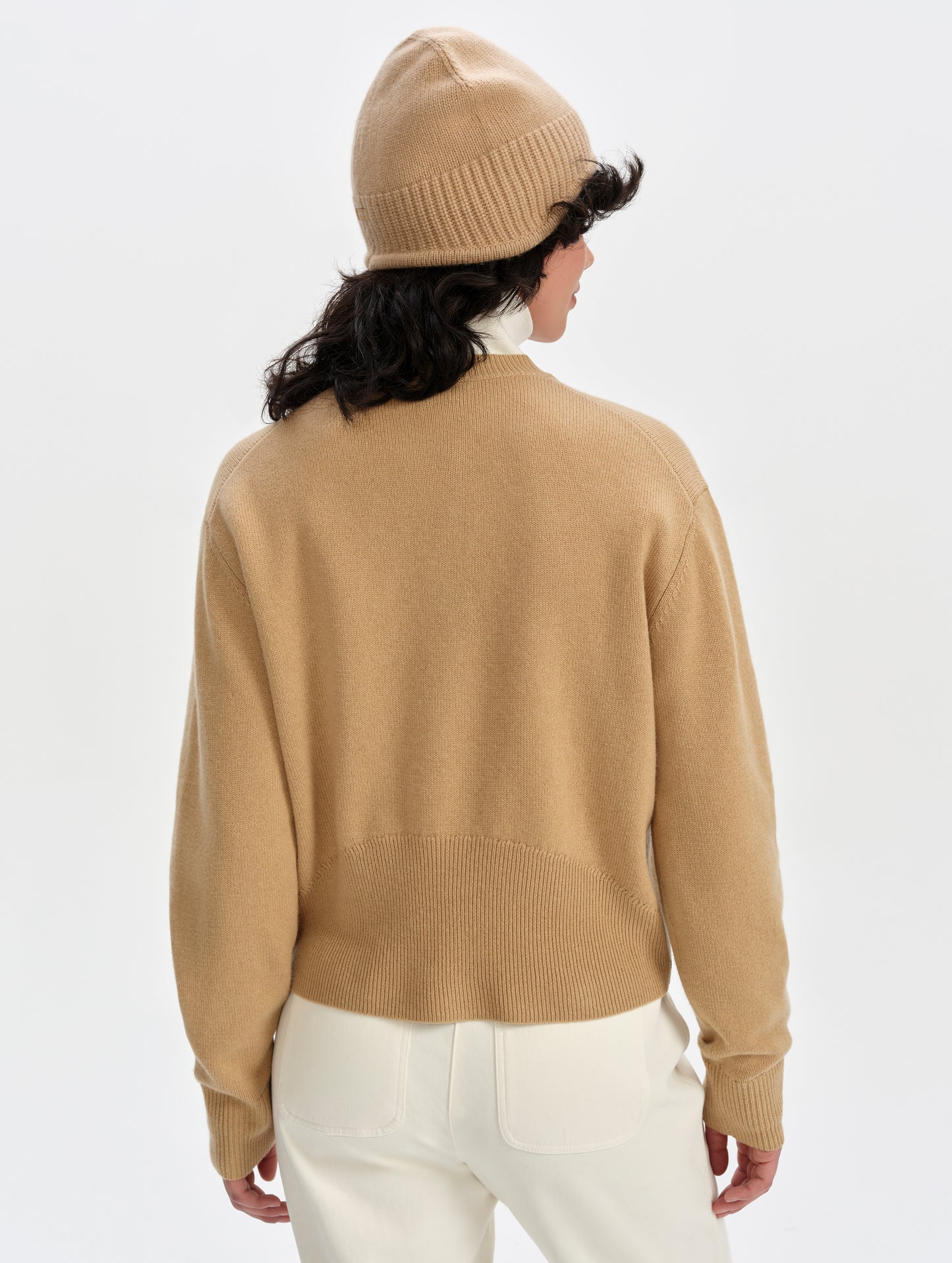 Rear upper-body view of woman wearing the Solace Cashmere Sweater in Latte Brown from AETHER Apparel.