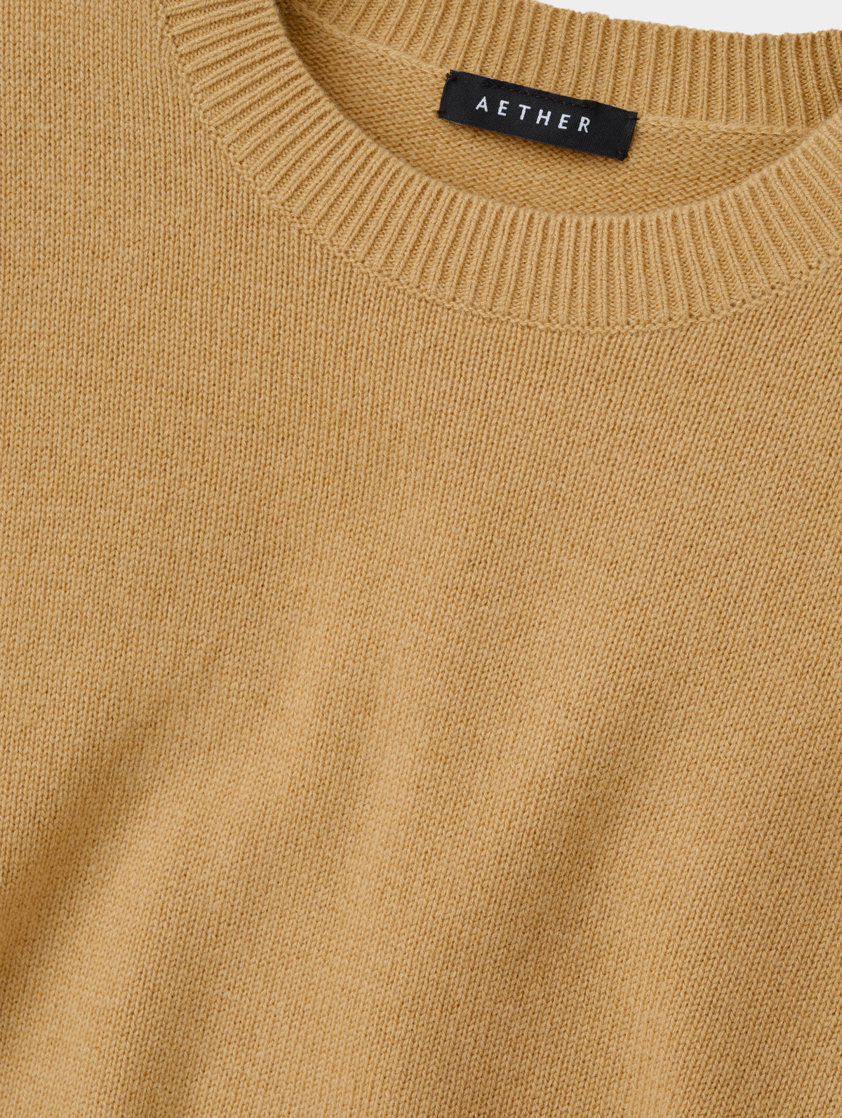 Closeup detailed view of the rib-knit collar and main body construction on the Solace Cashmere Sweater in Latte  Brown from AETHER Apparel.