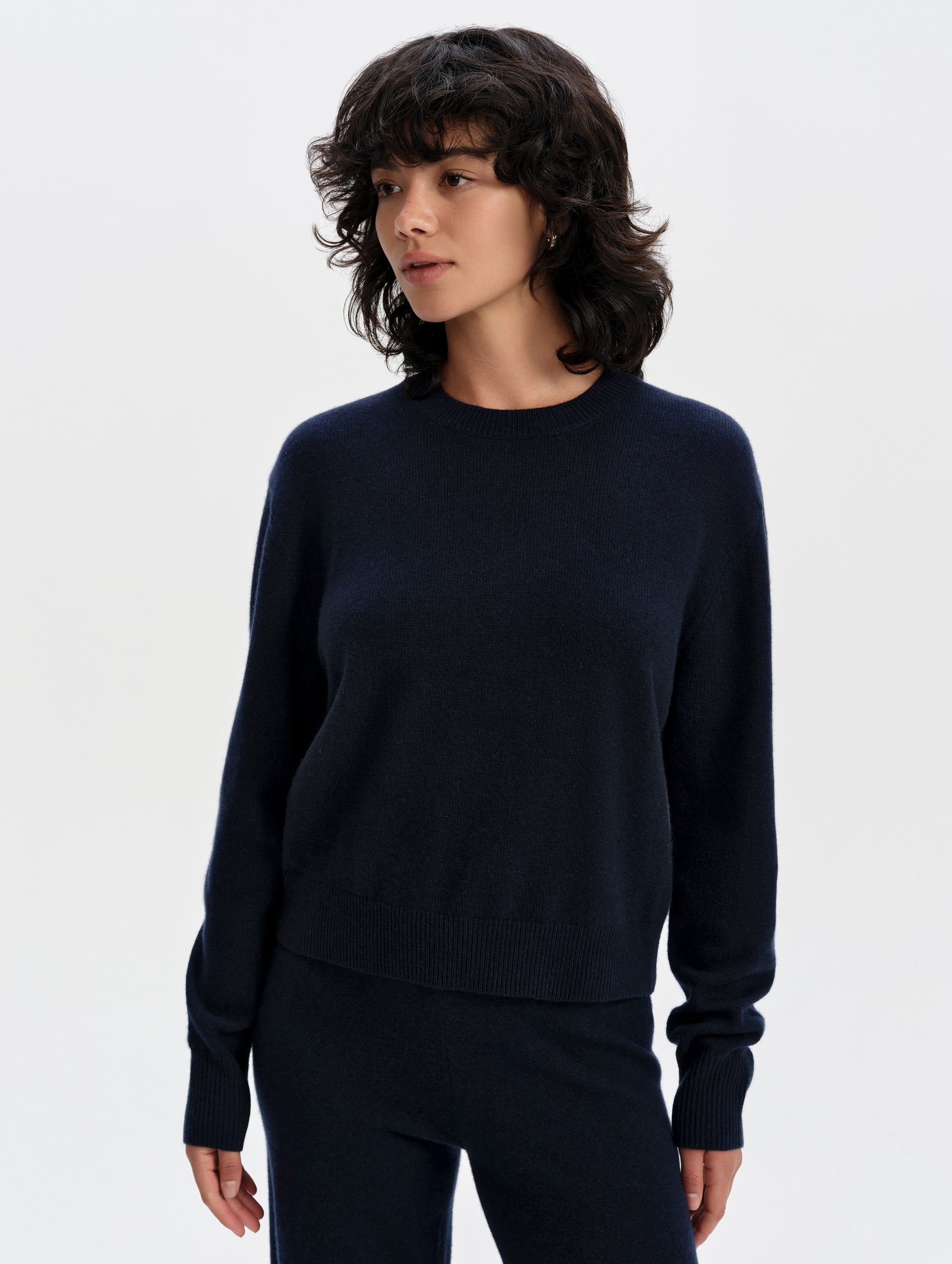 Front upper-body view of woman wearing the Solace Cashmere Sweater in Total Eclipse from AETHER Apparel.