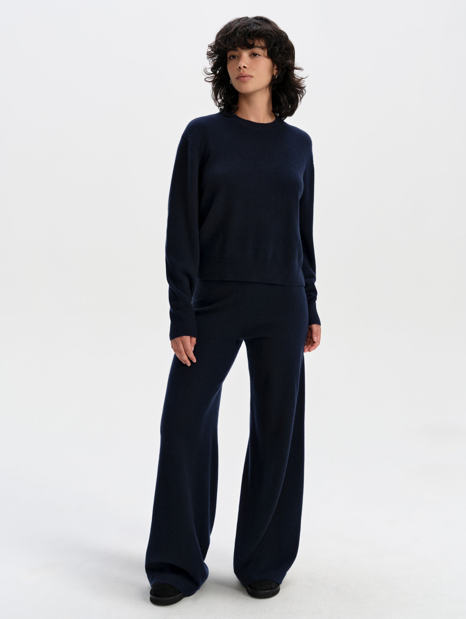 Front full-body view of woman wearing the Solace Cashmere Sweater in Total Eclipse from AETHER Apparel.