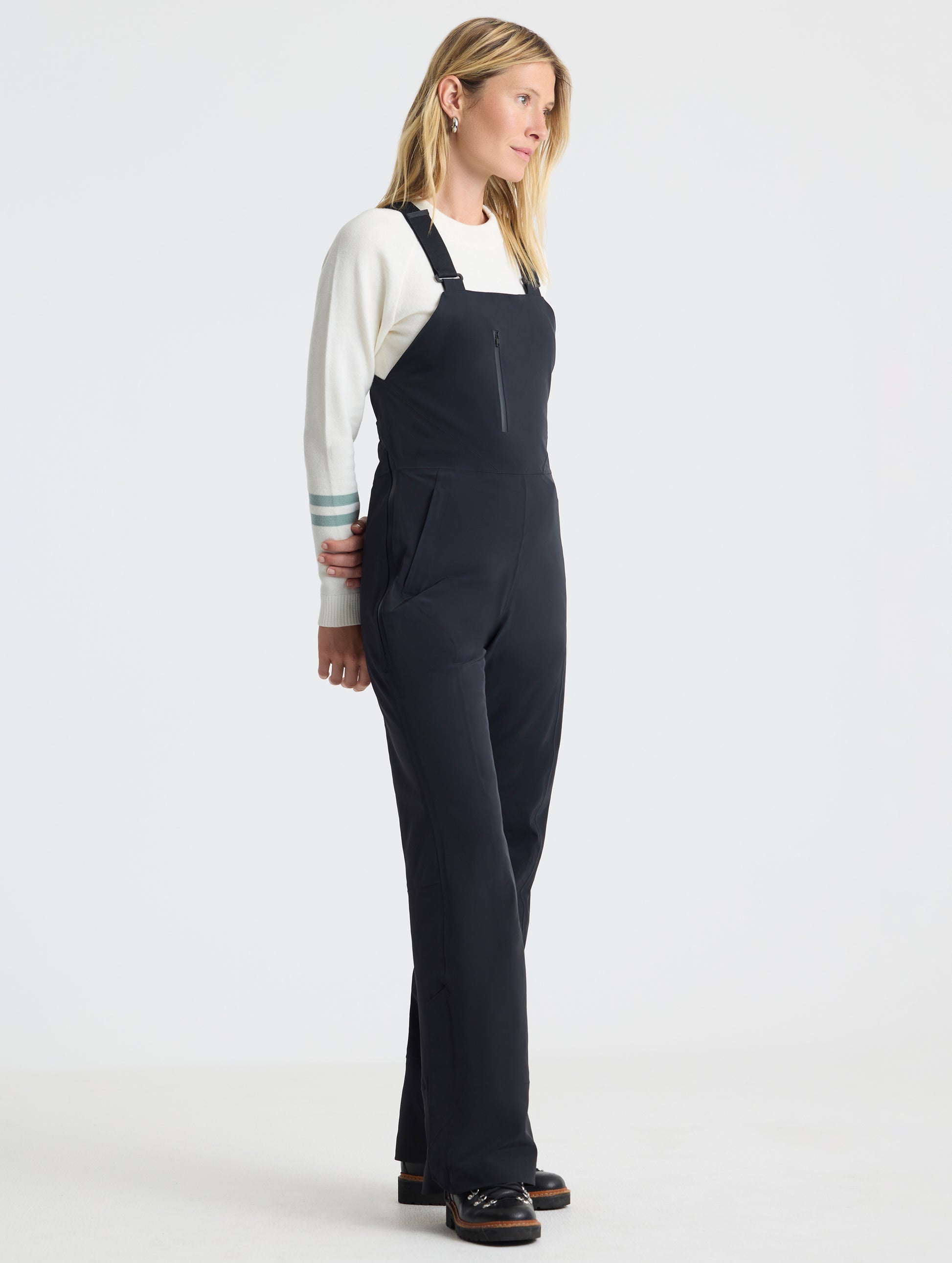 Front angled full-body view of woman wearing the Sophia Insulated Snow Bib in Onyx Black from AETHER Apparel.