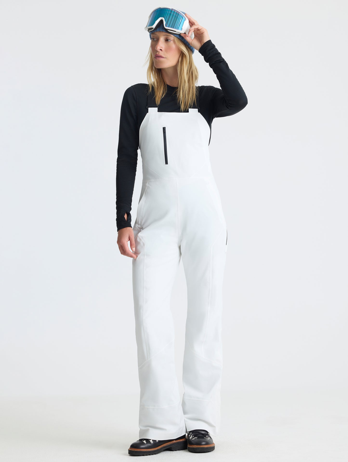 Front full-body view of woman wearing the Sophia Insulated Snow Bib in Winter White from AETHER Apparel.