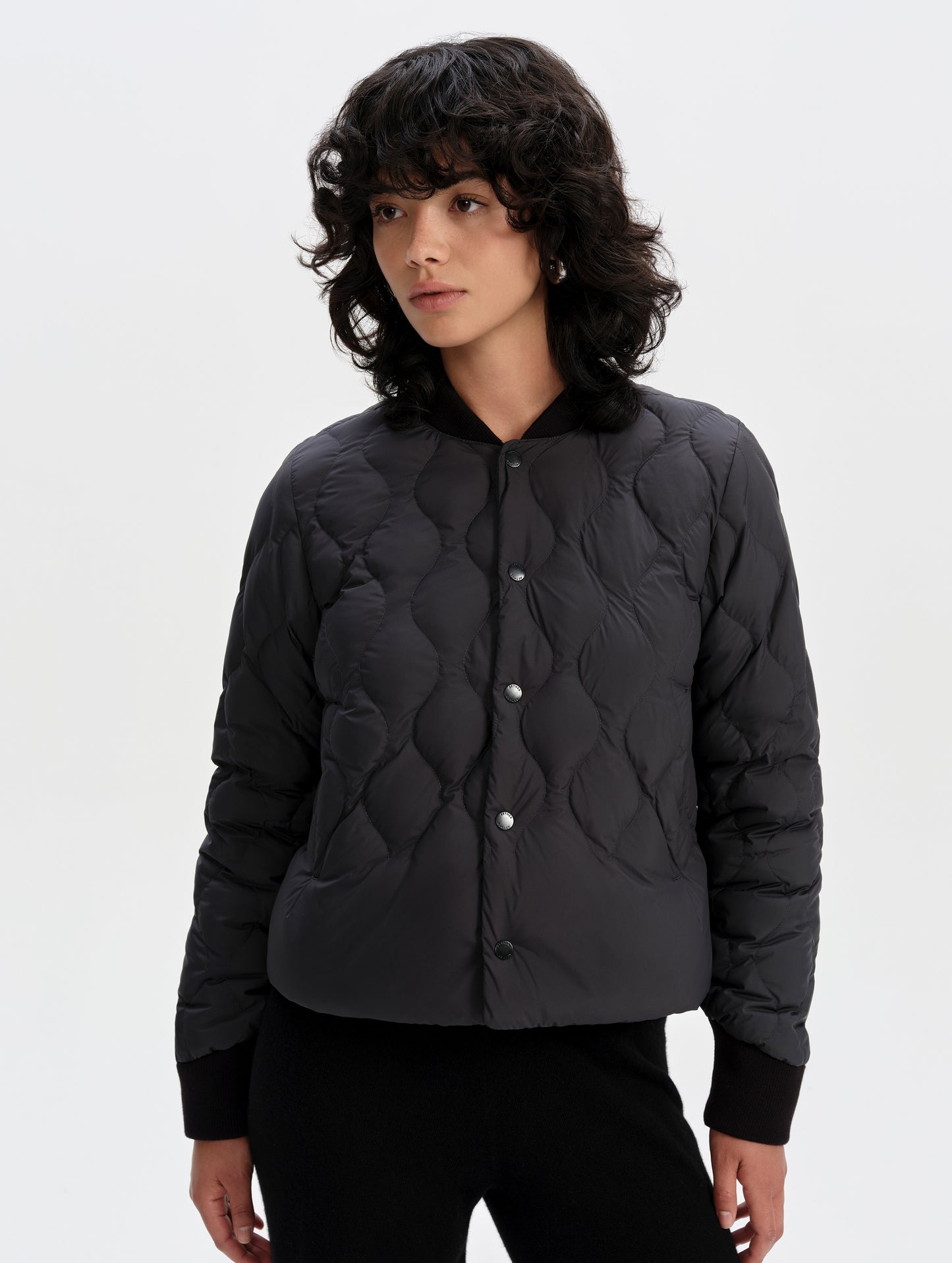 Front upper-body view of woman wearing the Stella Liner Jacket in Onyx Black from AETHER Apparel with center-front closed. 