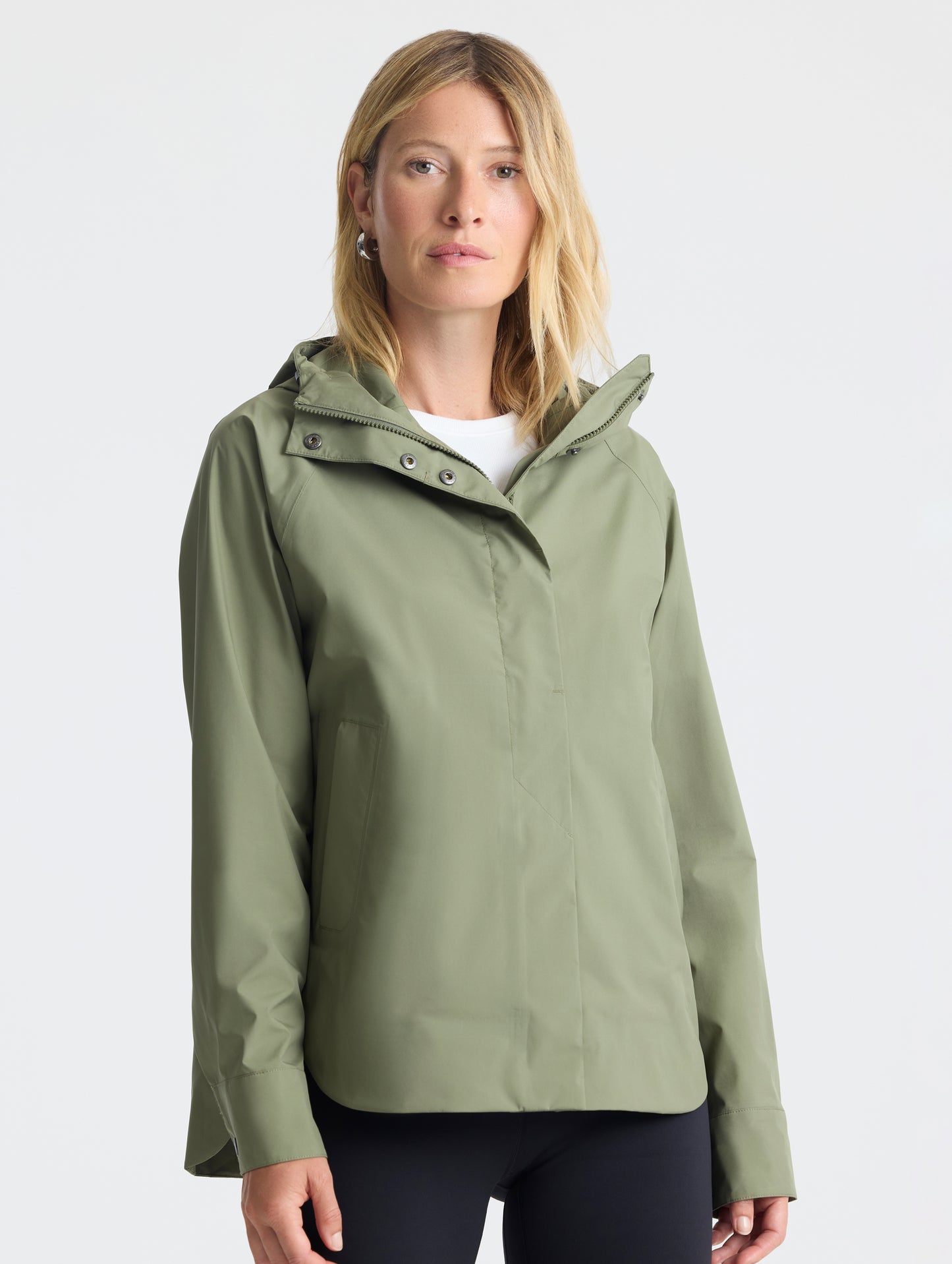 Front view of woman wearing Storm All-Weather Jacket in Fern Green from AETHER Apparel.