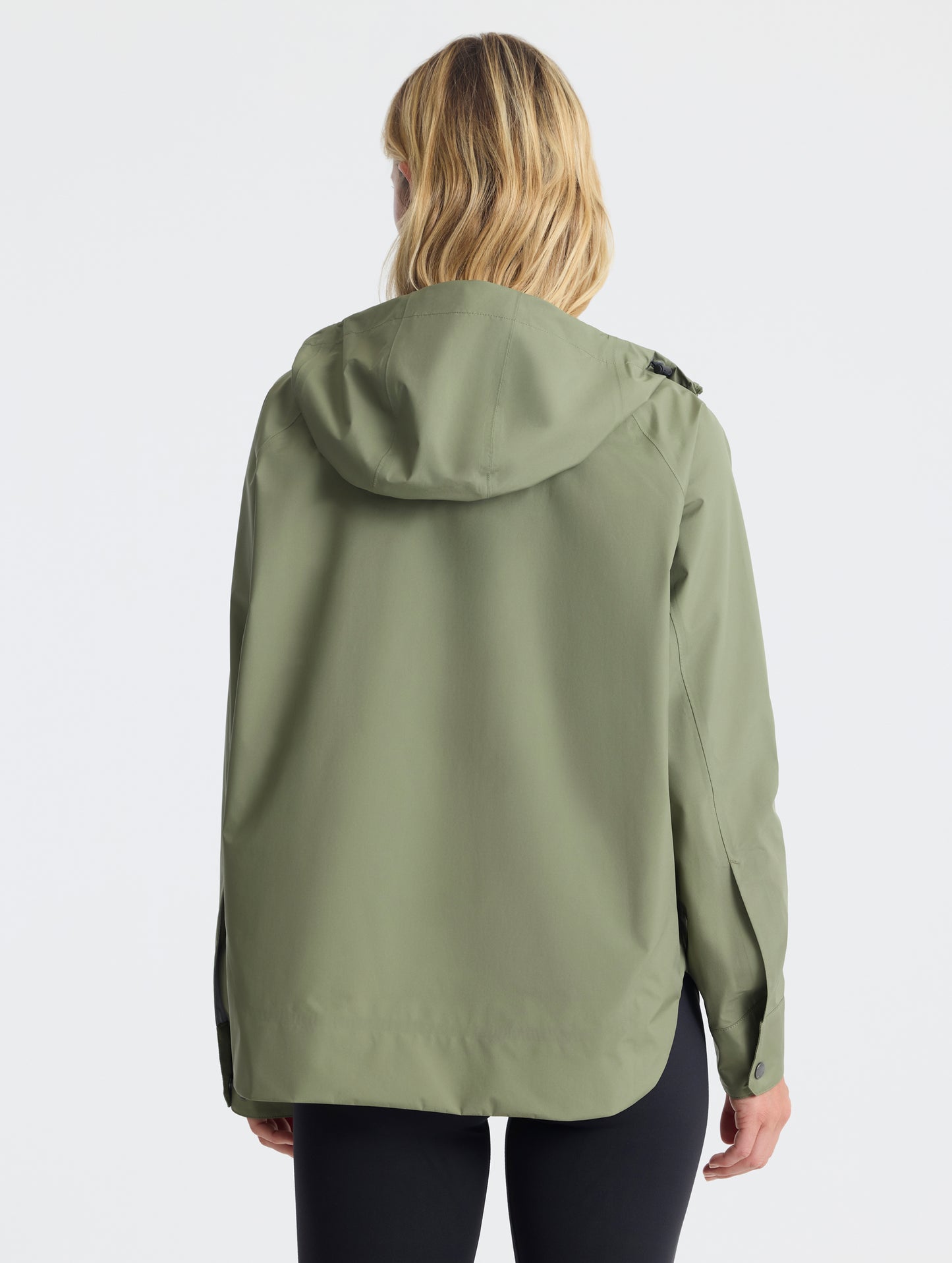 Rear view of woman wearing Storm All-Weather Jacket in Fern Green from AETHER Apparel.