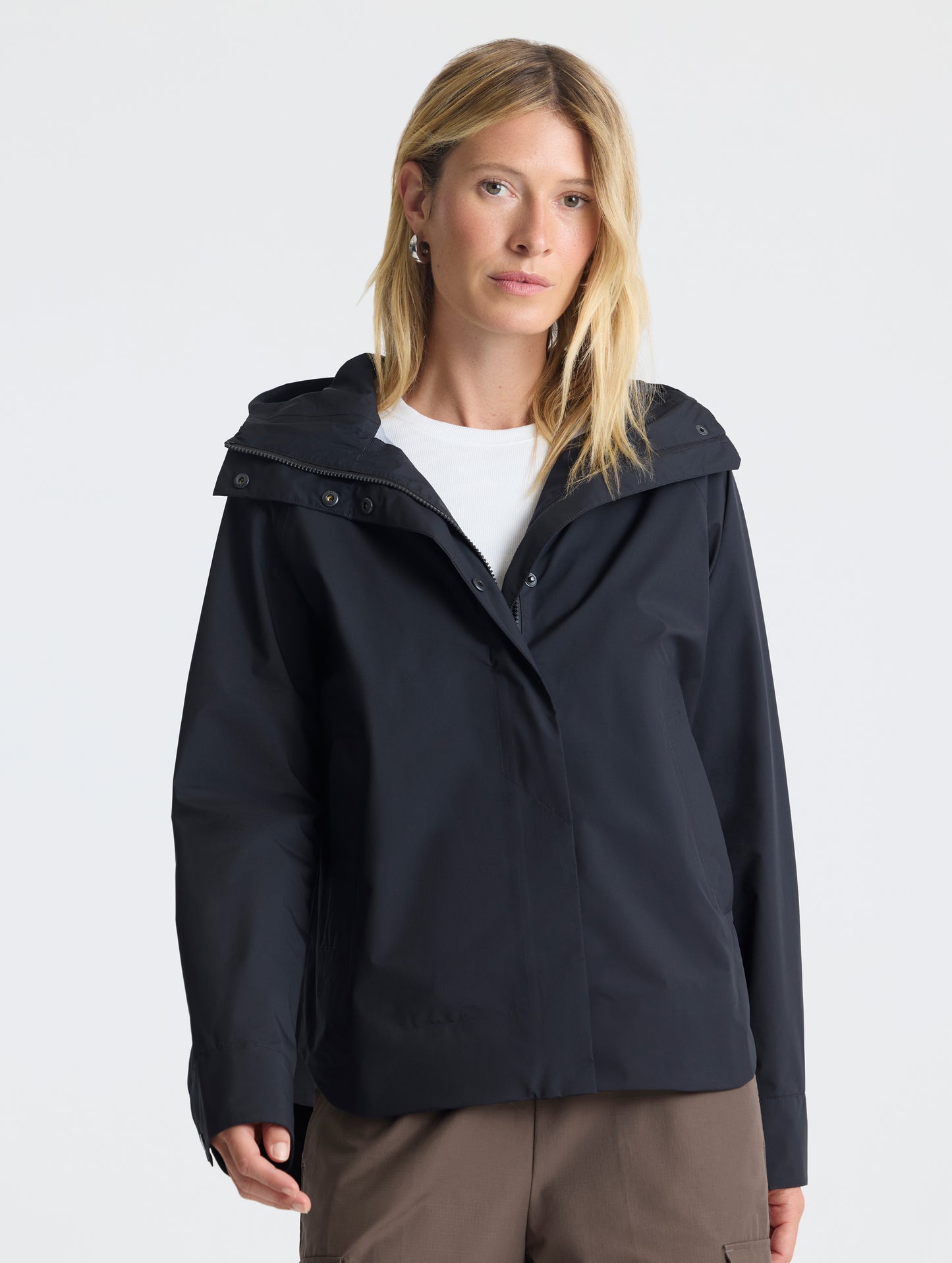 Front view of woman wearing Storm All-Weather Jacket in Onyx Black from AETHER Apparel.