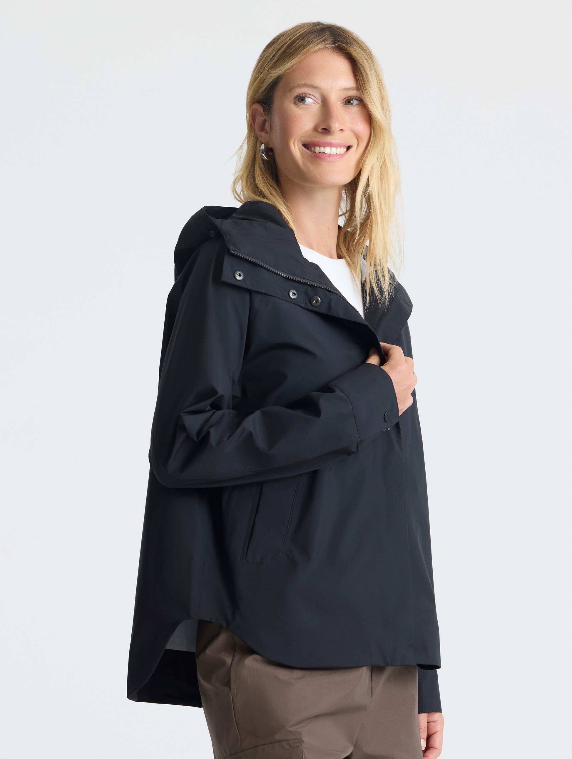 Angled view of woman wearing Storm All-Weather Jacket in Onyx Black from AETHER Apparel.