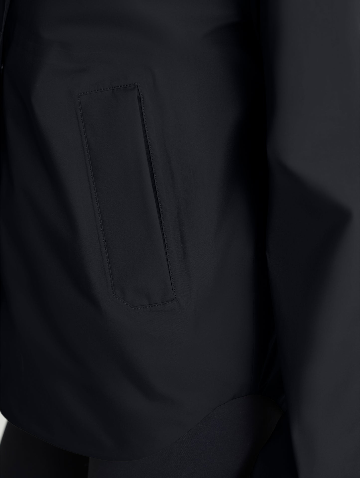 Closeup view of zipped right hand pocket of Storm All-Weather Jacket in Onyx Black from AETHER Apparel.