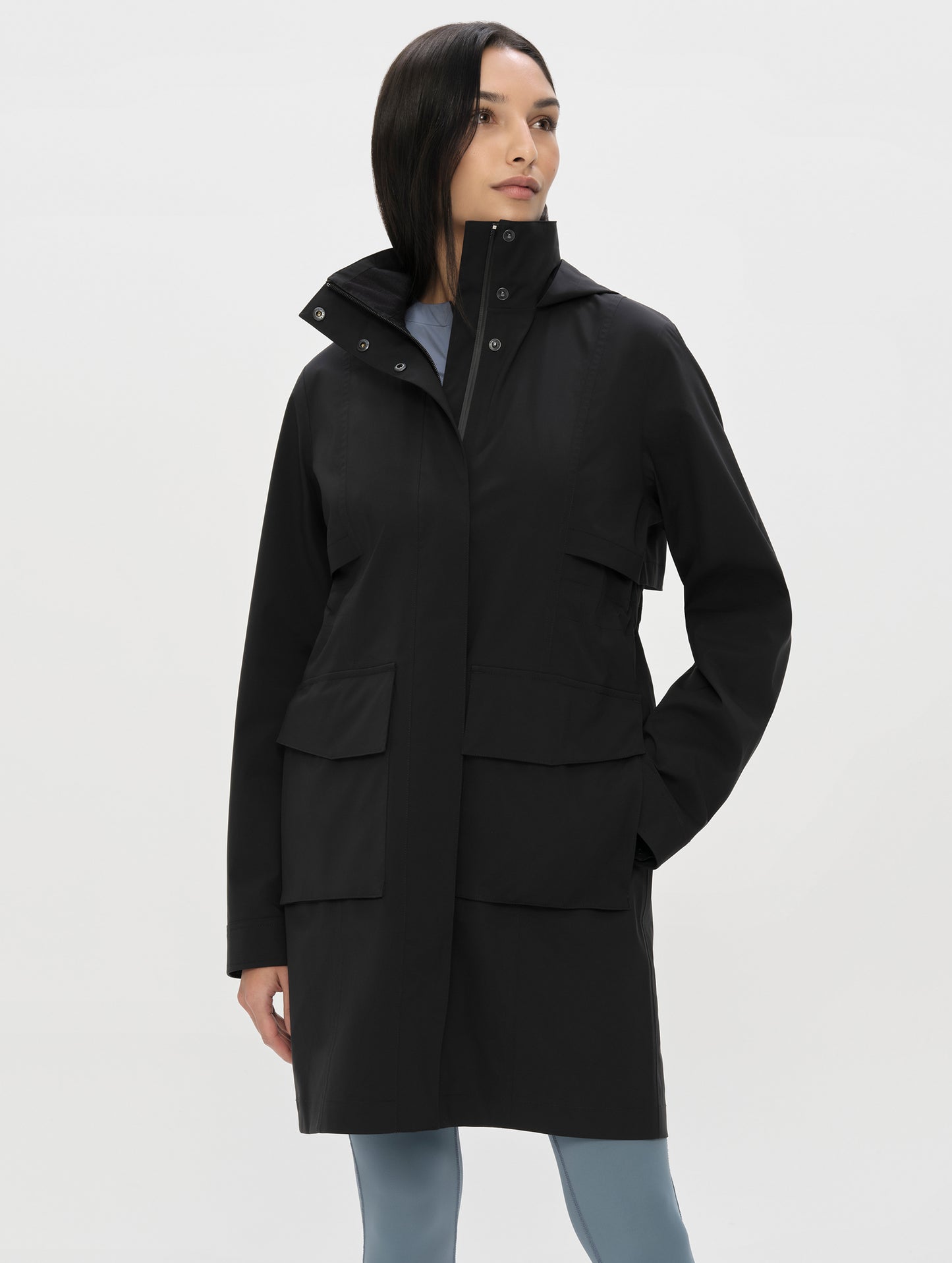 Front, upper-body view of woman wearing the Wallace Rain Parka in Onyx Black from AETHER Apparel.