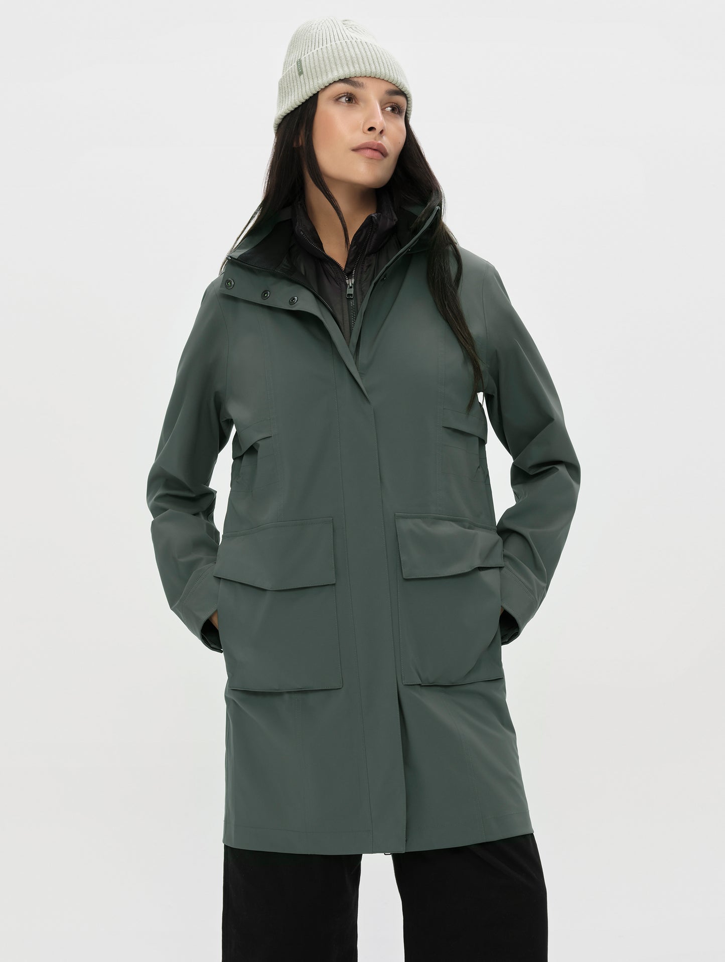 Front upper-body view of woman wearing the Wallace Rain Parka in Saville Green from AETHER Apparel.