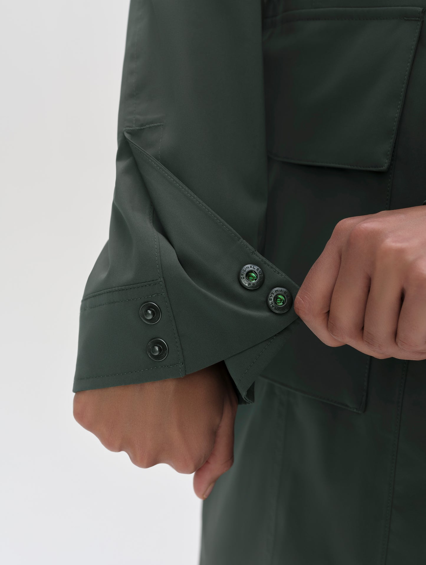 Closeup detailed view of the dual-snap sleeve cuffs on the women's Wallace Rain Parka in Saville Green from AETHER Apparel.