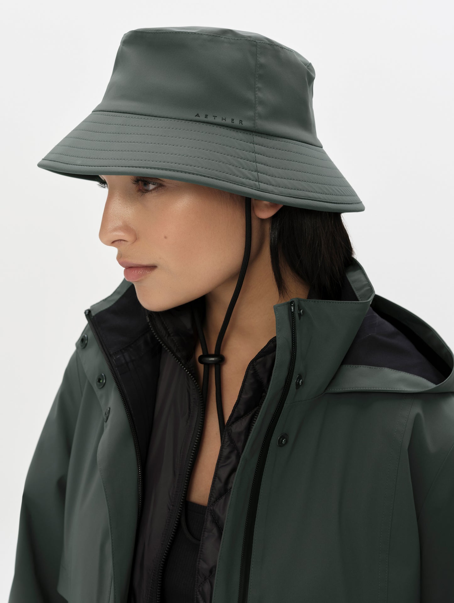 Front right angled view of woman wearing the Wallace Bucket Hat in Saville Green from AETHER Apparel.