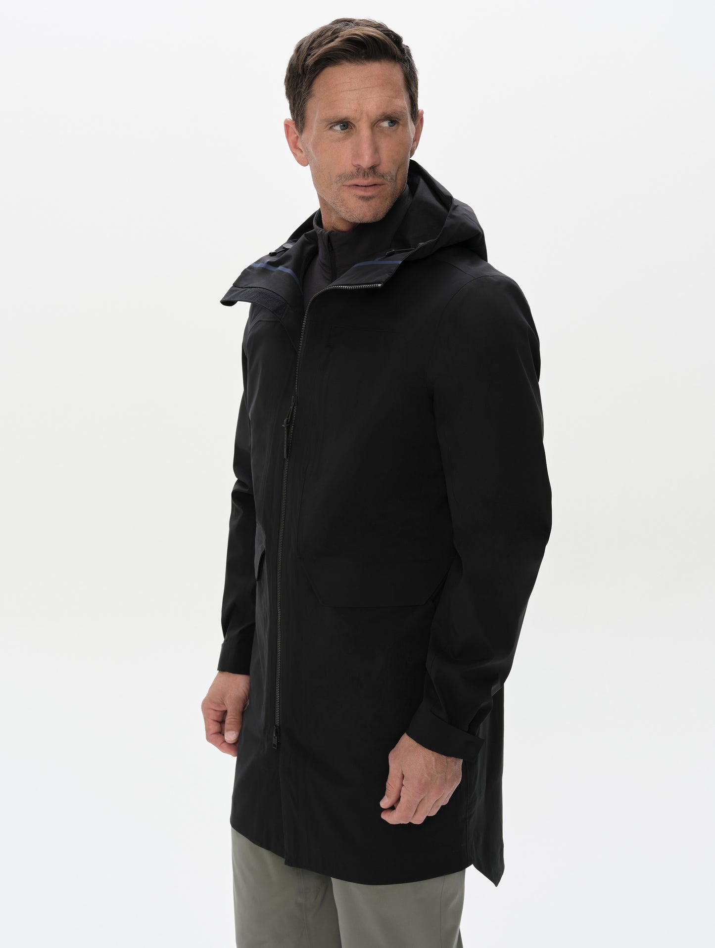 Front upper-body view of man wearing the Wallace Rain Parka in Onyx Black from AETHER Apparel with open collar. 