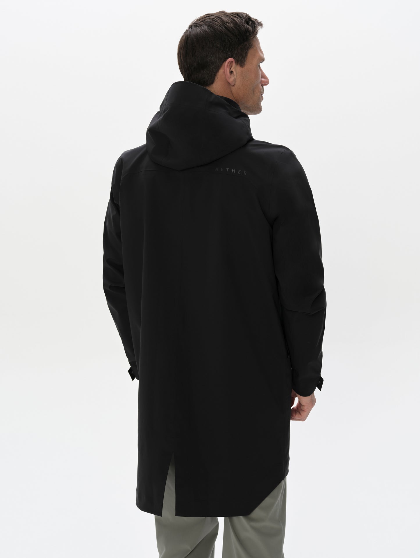 Rear upper-body view of man wearing the Wallace Rain Parka in Onyx Black from AETHER Apparel.