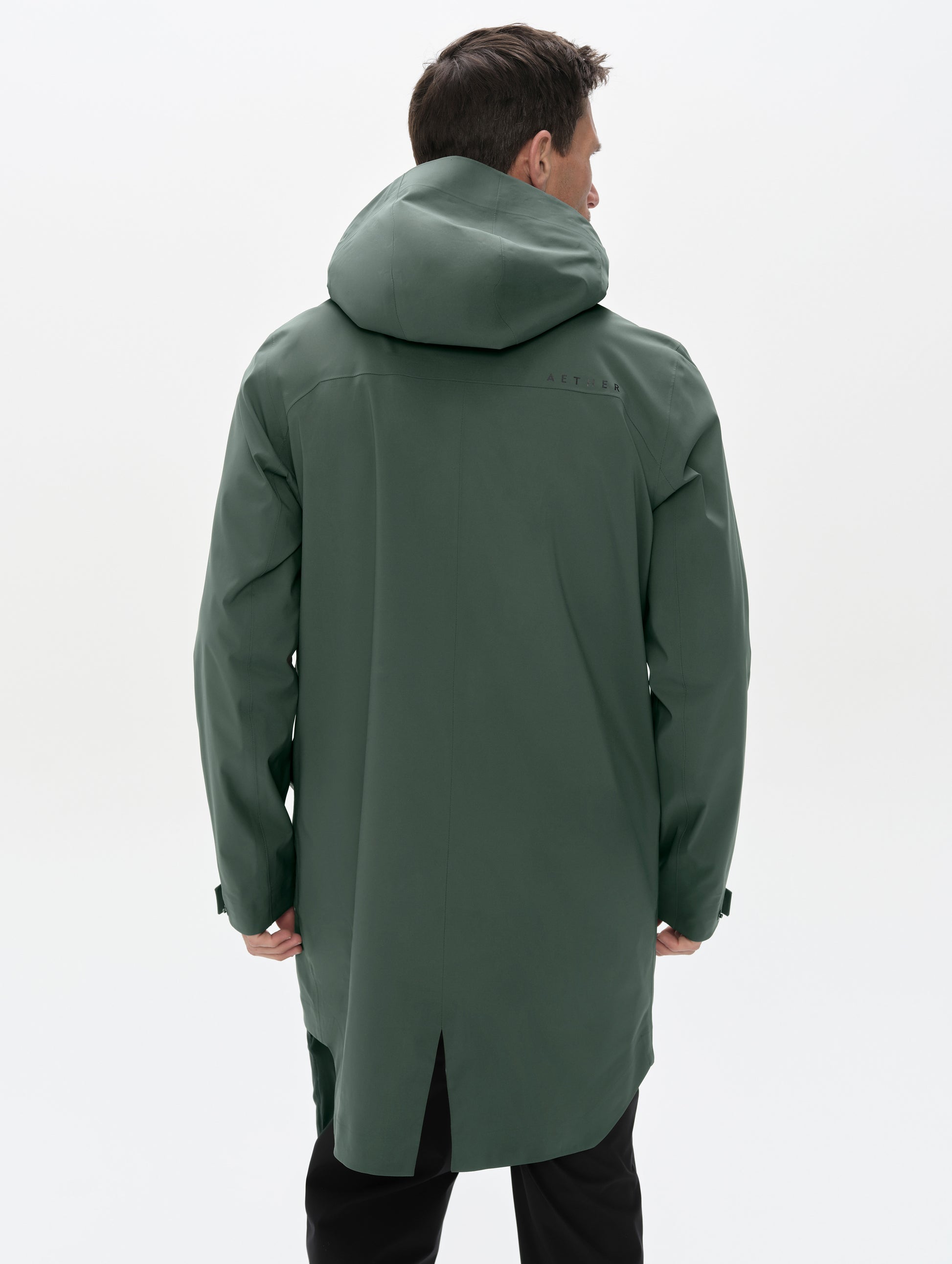 Rear upper-body view of man wearing the Wallace Rain Parka in Saville Green from AETHER Apparel.