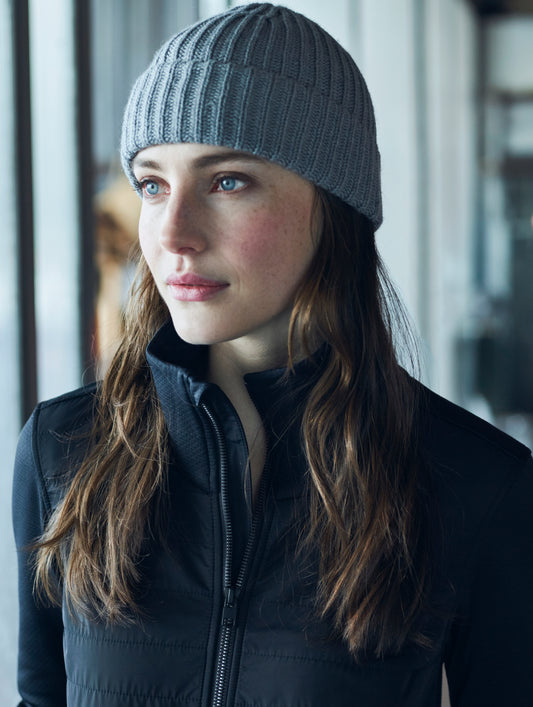 Woman wearing grey knitted beanie from AETHER Apparel.