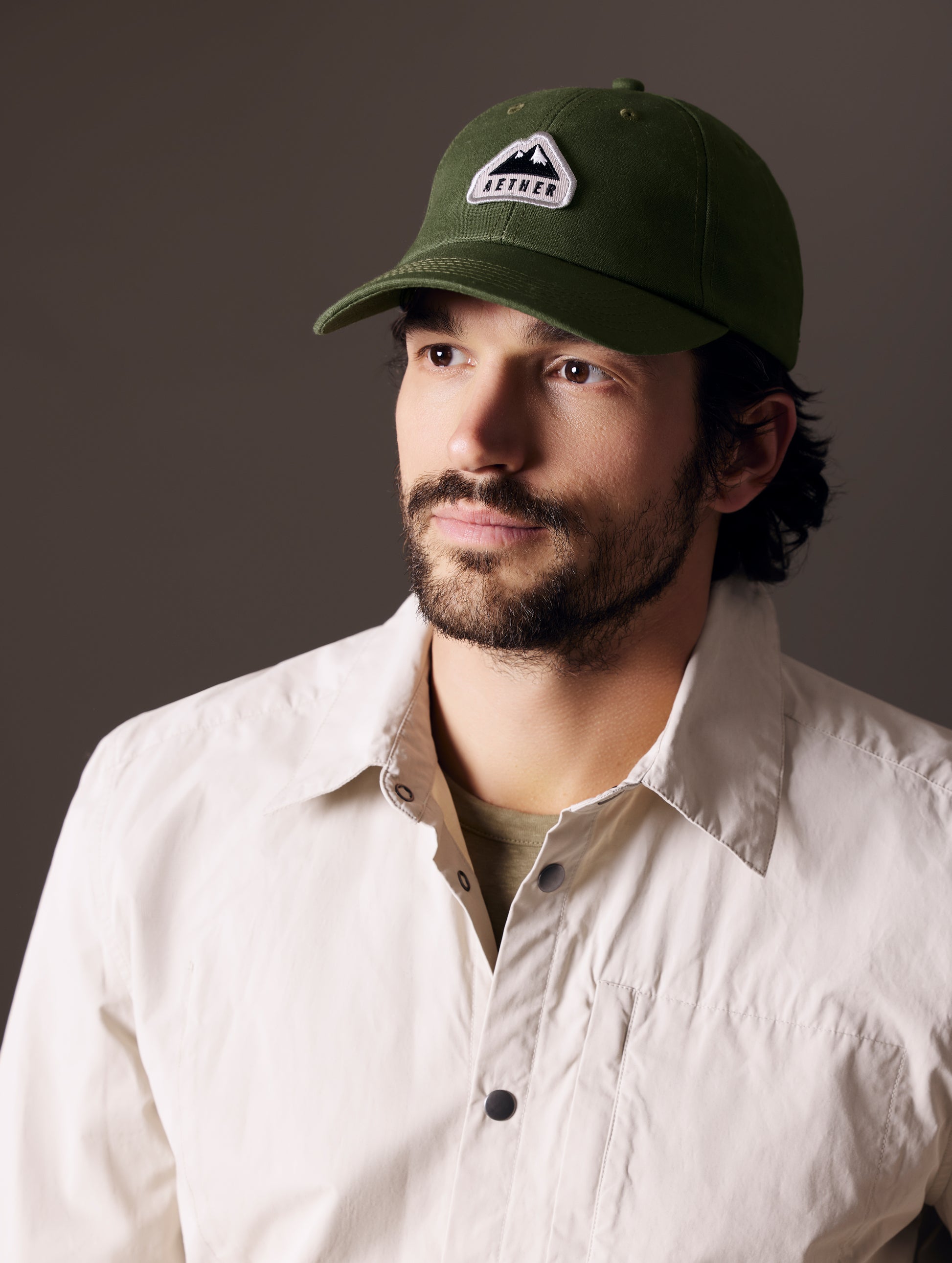 man wearing green AETHER Mountain Hat