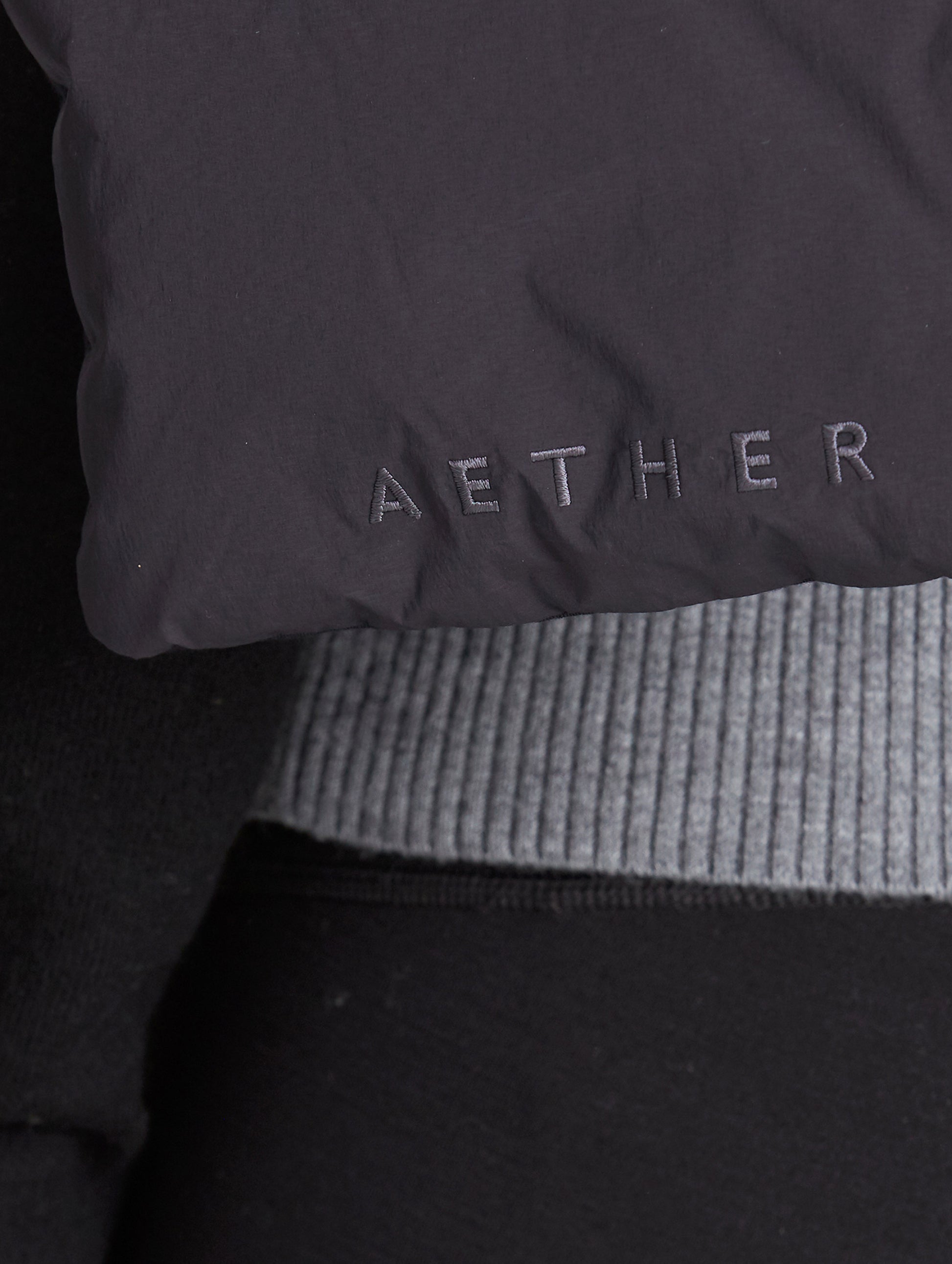 AETHER logo on black quilted down scarf