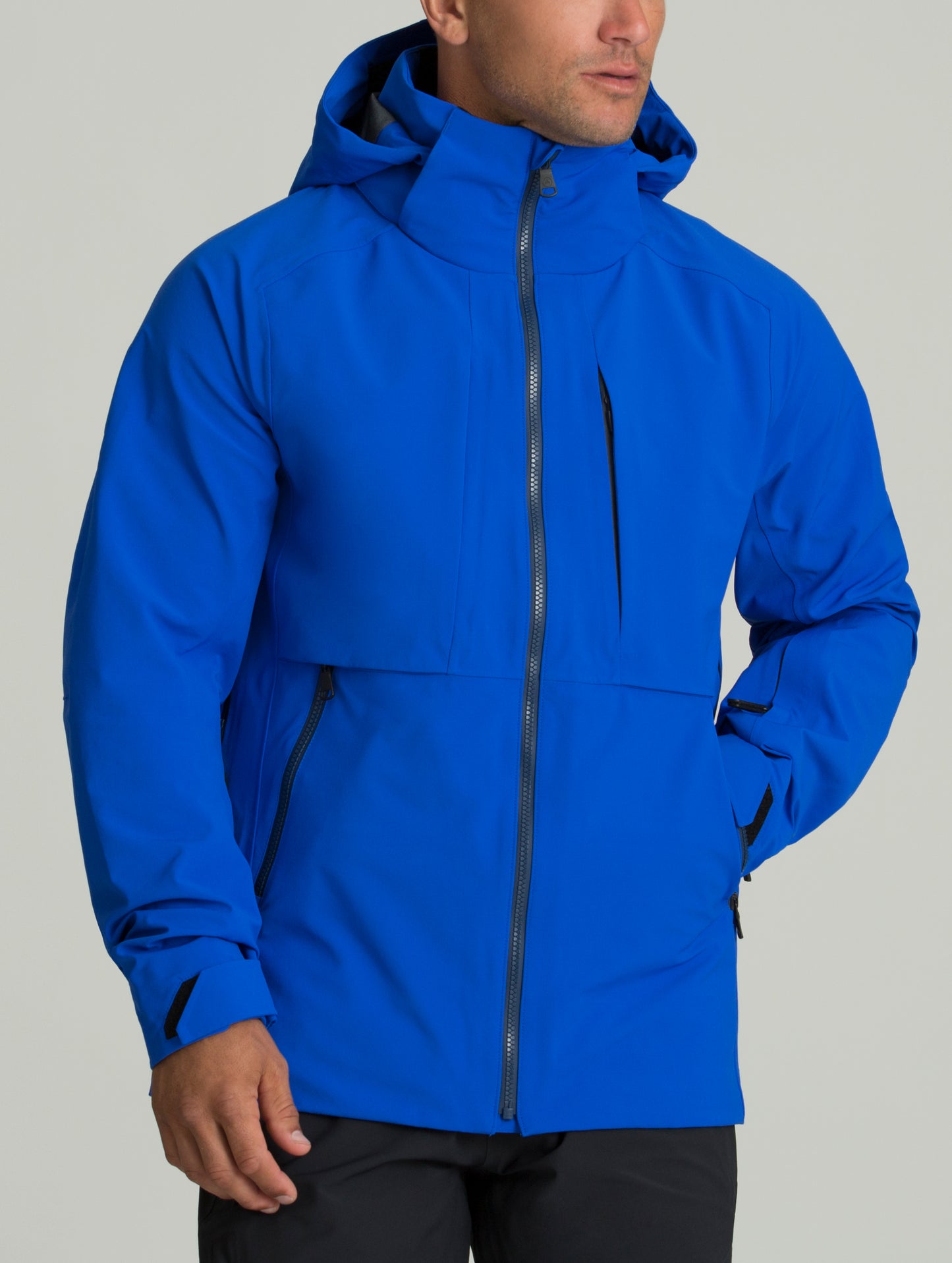 Man indoors wearing blue Access Shell from AETHER Apparel.