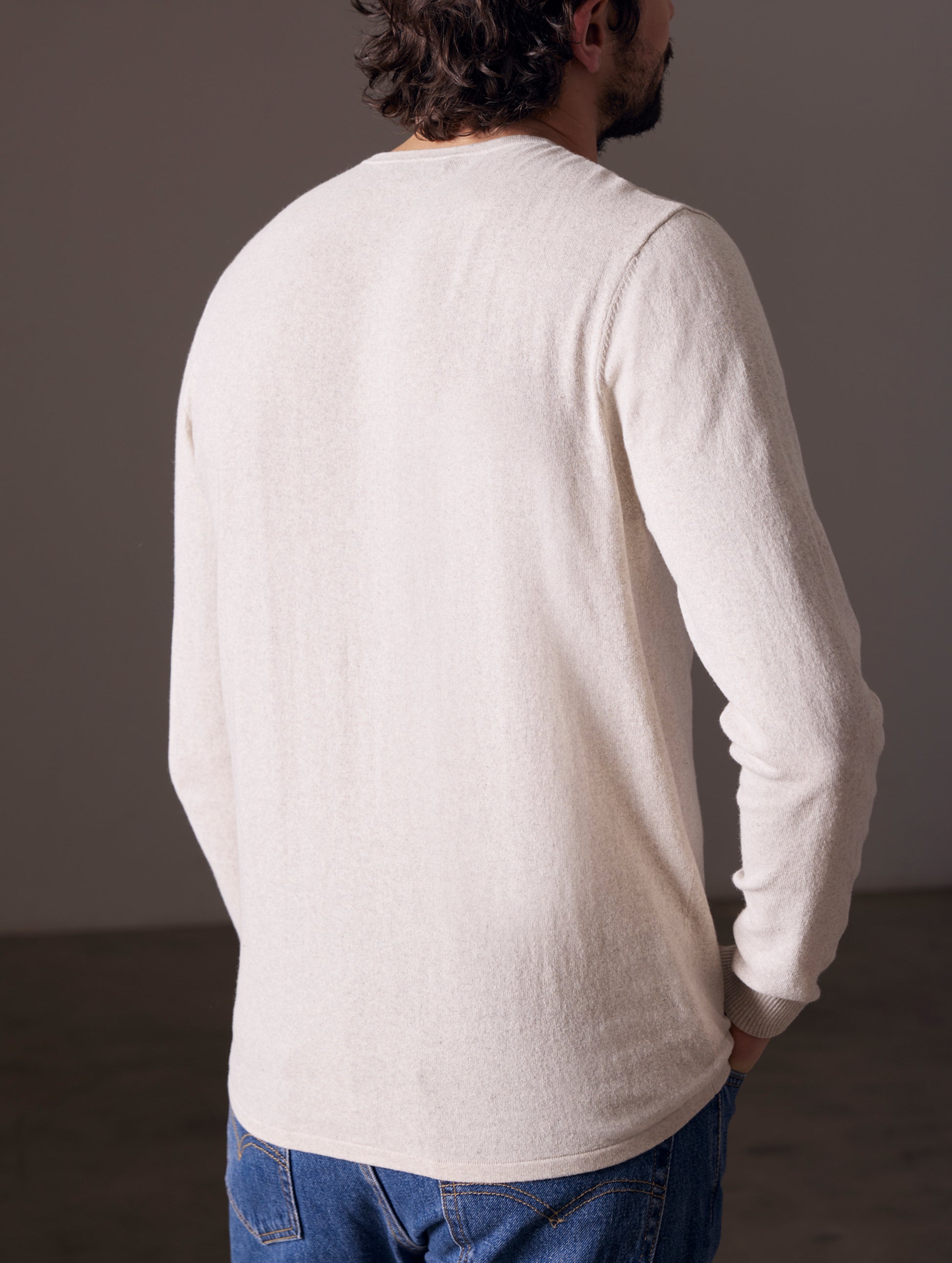 Back view of man wearing light tan sweater