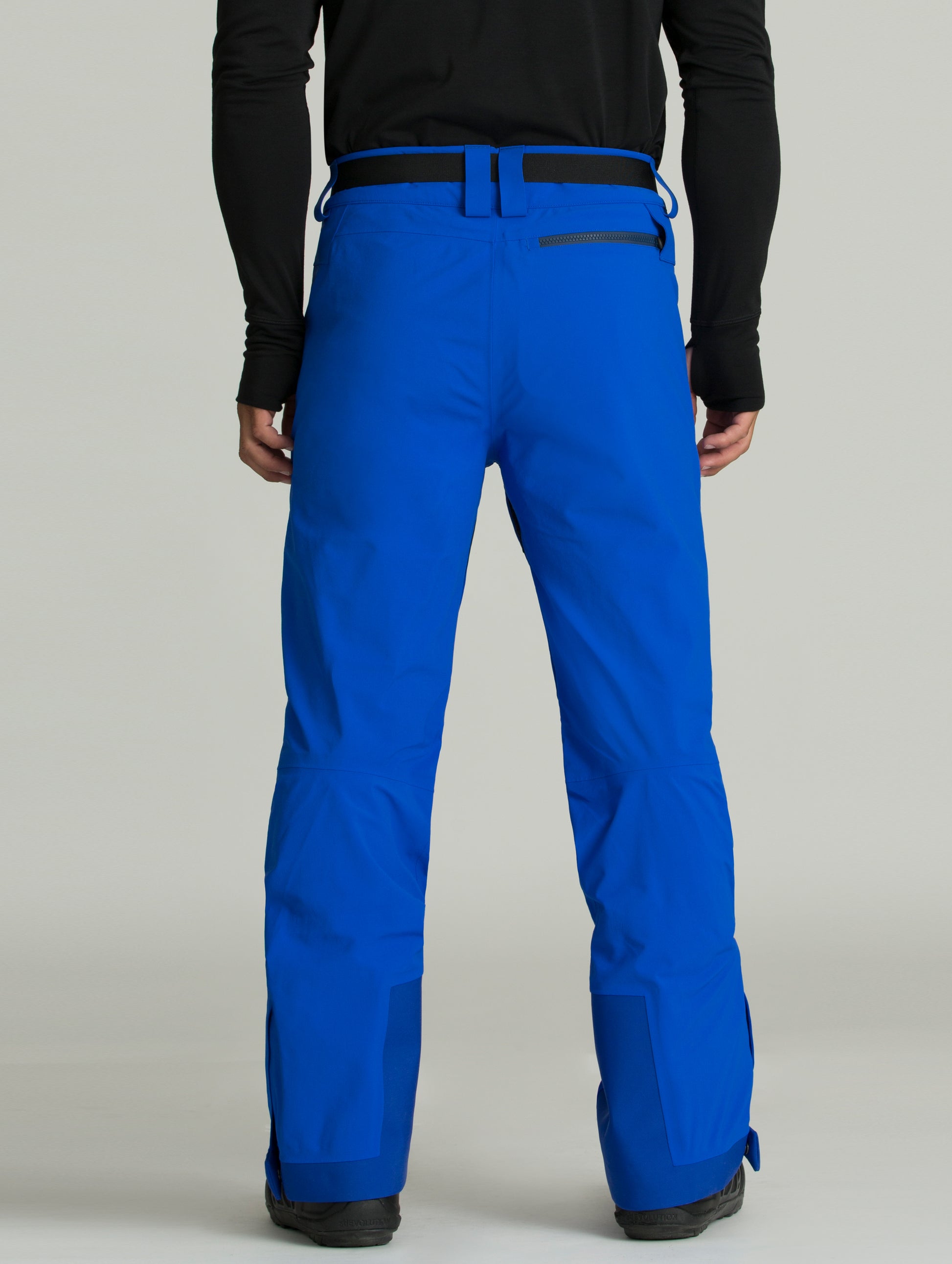 Back view of man wearing a blue Approach Snow Pant from AETHER Apparel.